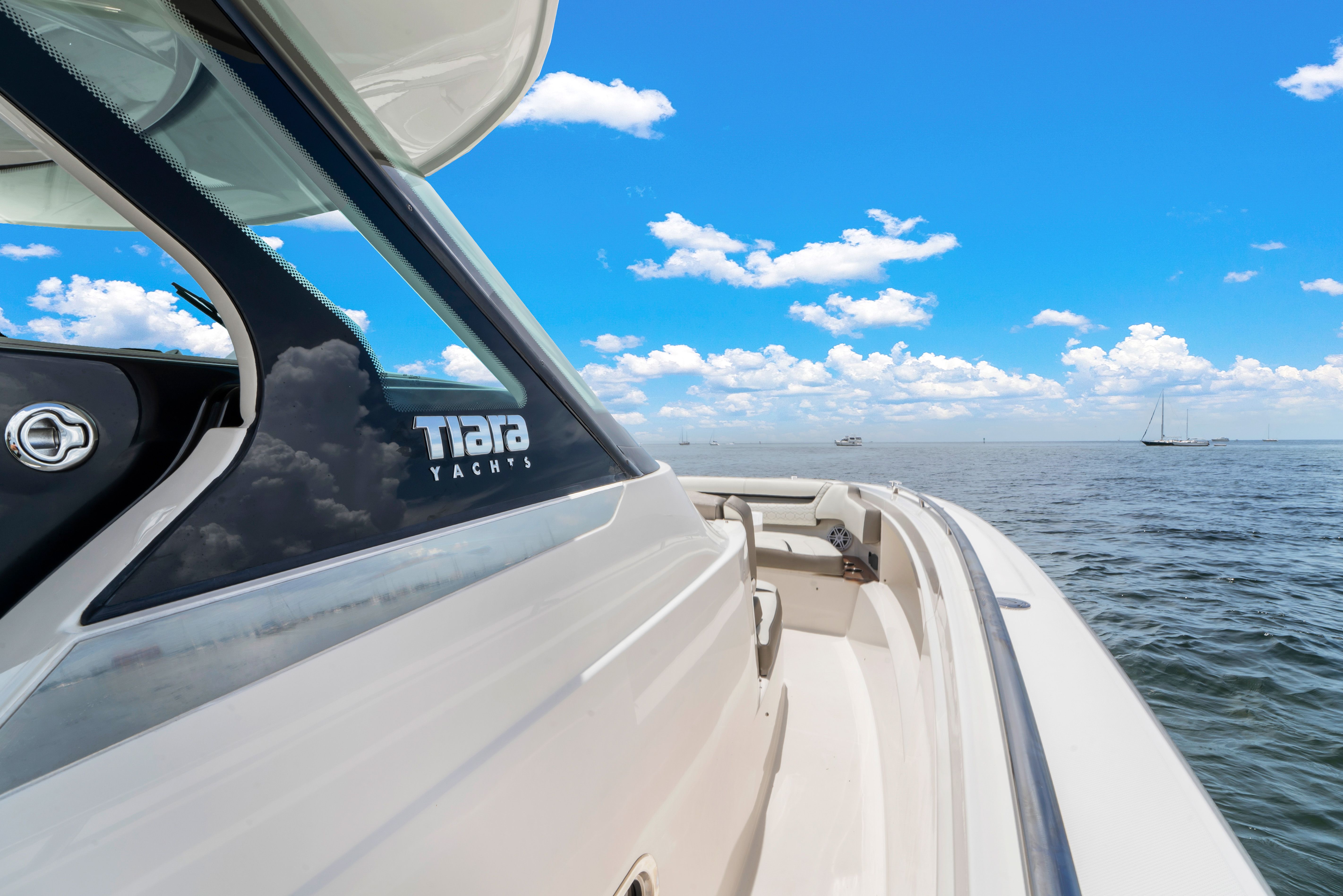 The Tiara Yachts 38 LS cruises on calm water under a clear blue sky.