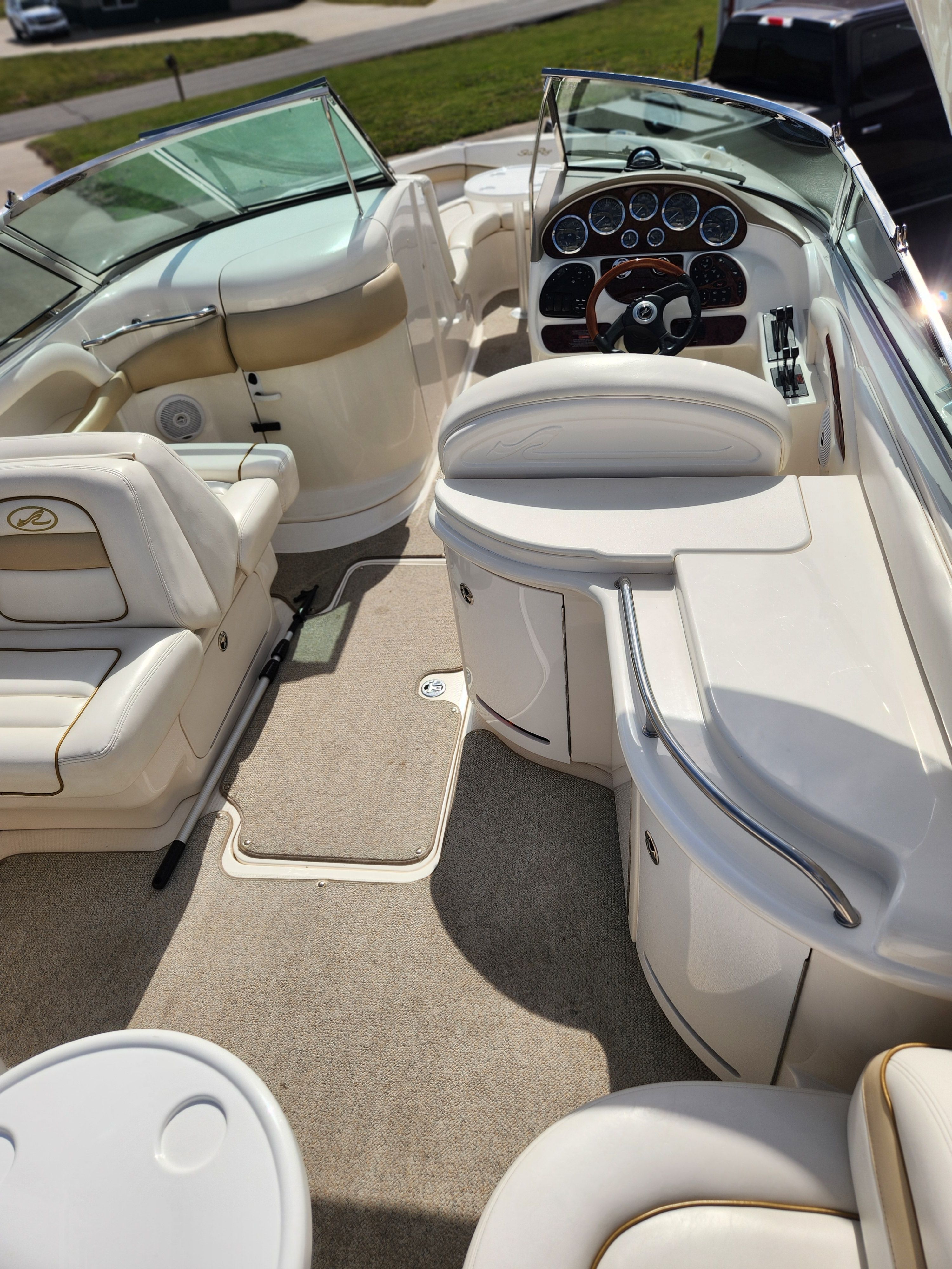 The interior of a Sea Ray 290 BR boat with beige seating and a helm station.