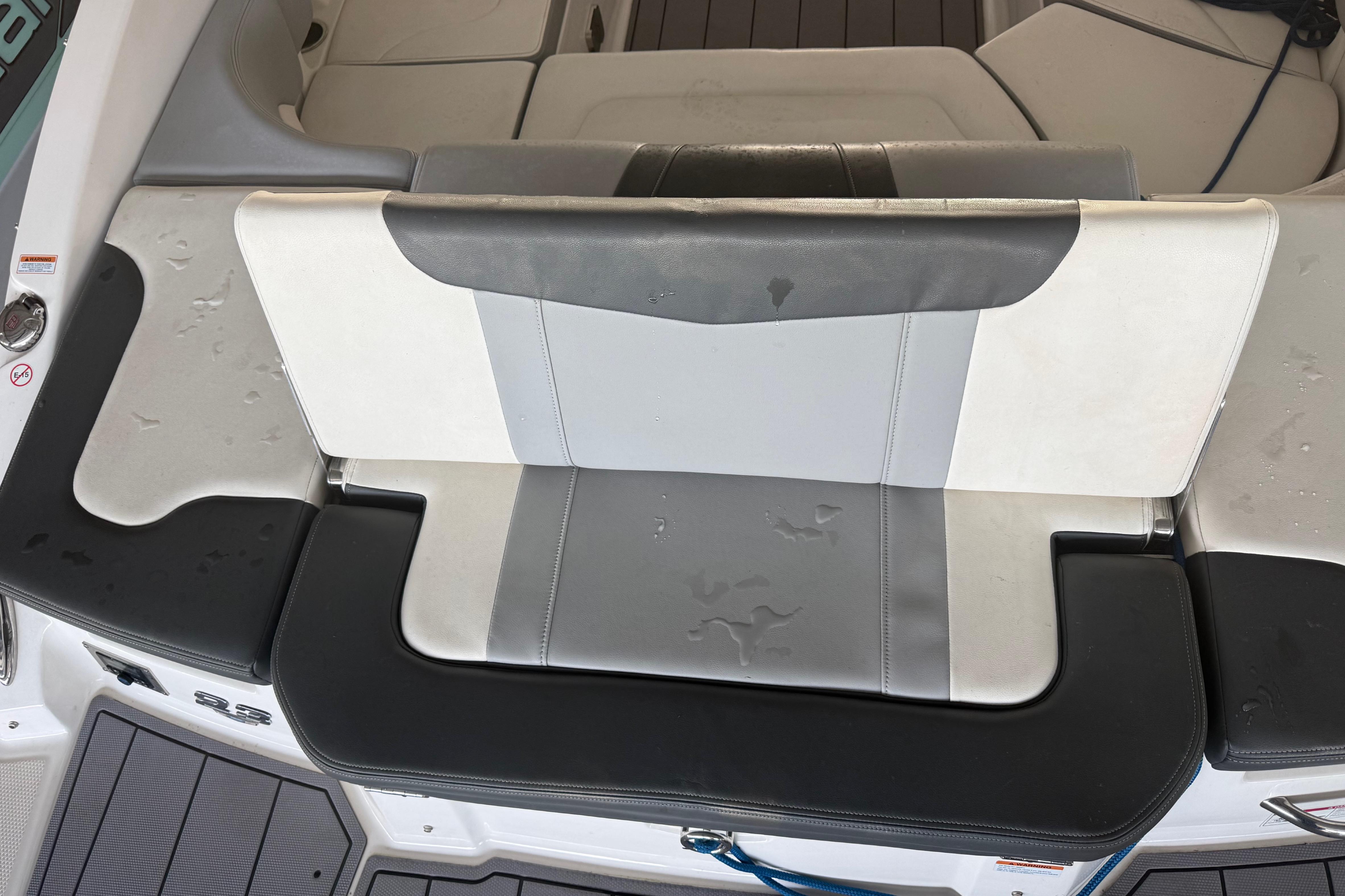 2023 Chaparral 230 SSi boat seat with gray and white upholstery, showing water droplets.
