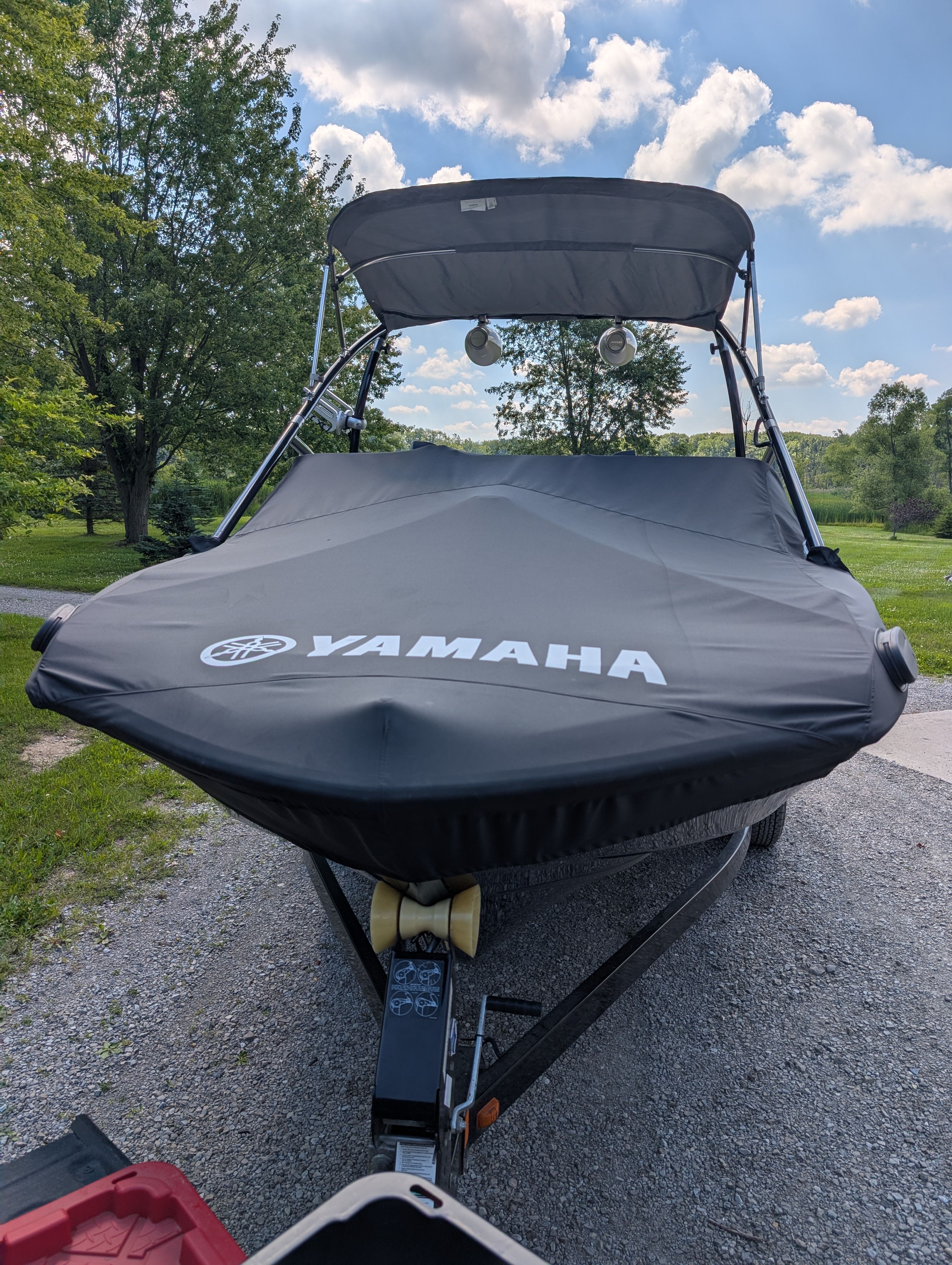 2014 Yamaha AR192 boat with cover on a trailer, surrounded by trees and sky.