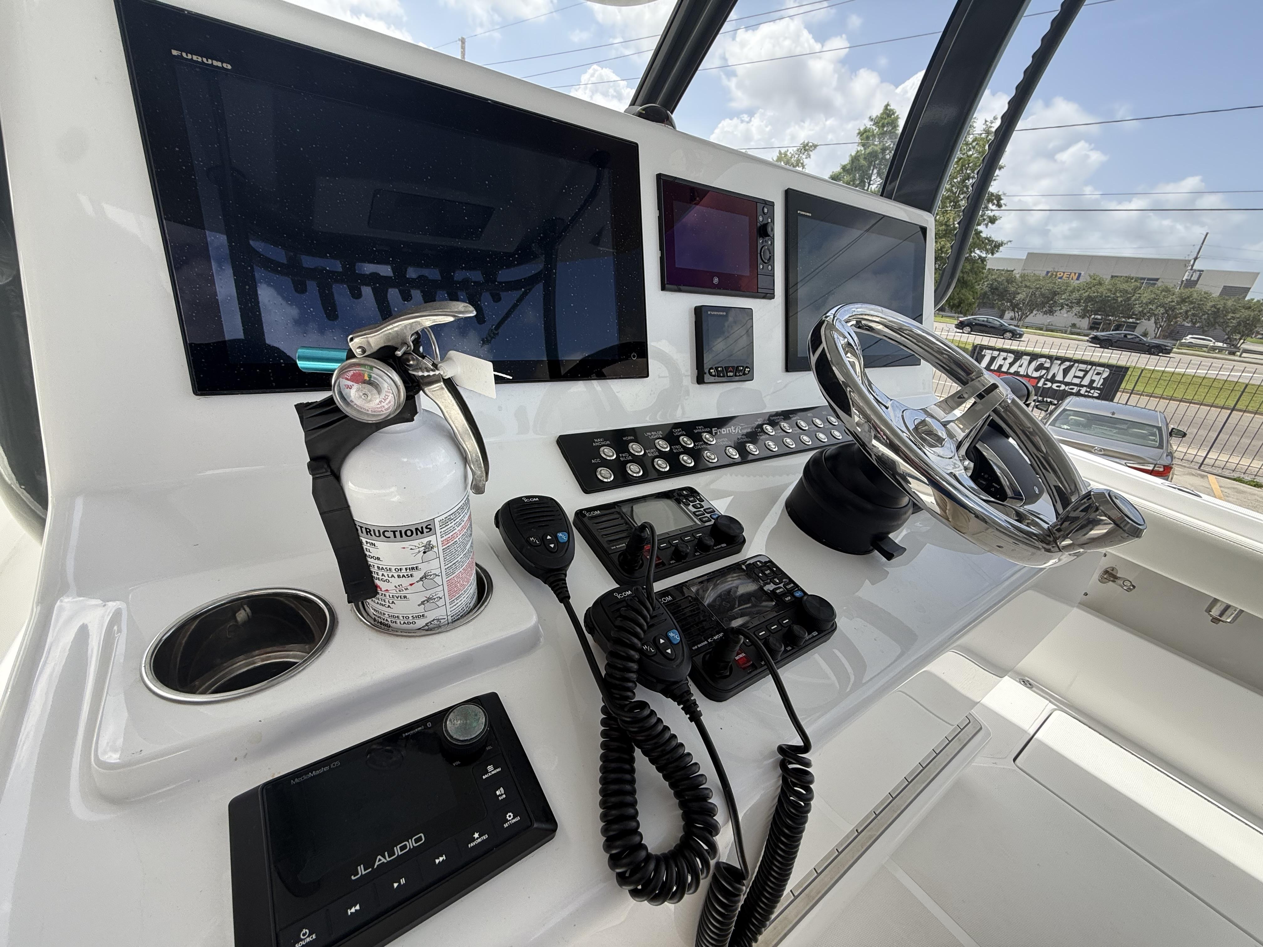 2024 Front Runner 39 CC boat dashboard with steering wheel, electronics, and fire extinguisher.