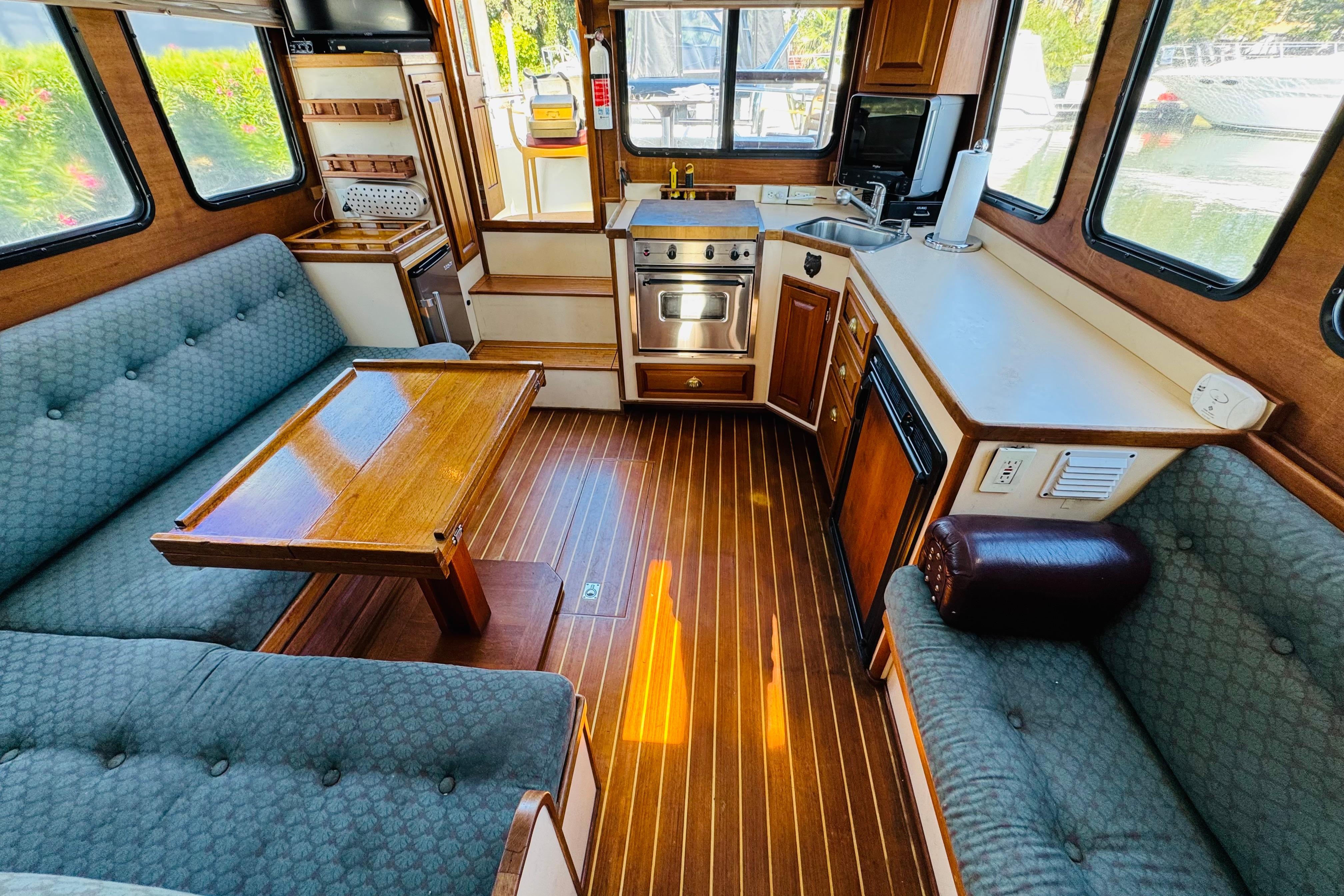 Interior of a 1996 Nordic Tug 32, featuring a cozy seating area and compact kitchen.
