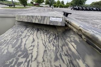 2026 Tracker Grizzly 1860 Utility boat with camouflage pattern in a parking lot.