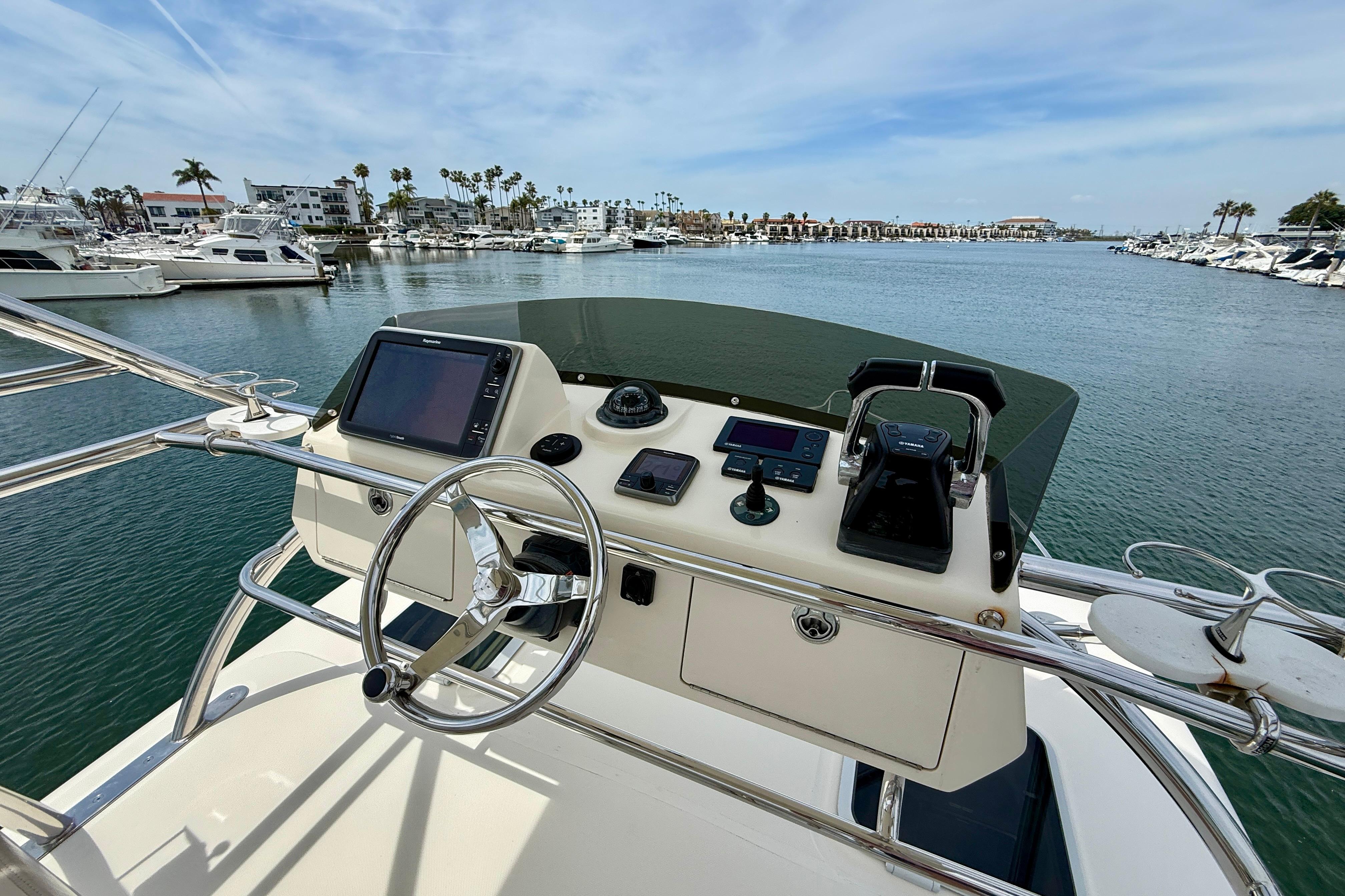 Helm of 2012 Pursuit OS 345 Offshore boat with marina view.