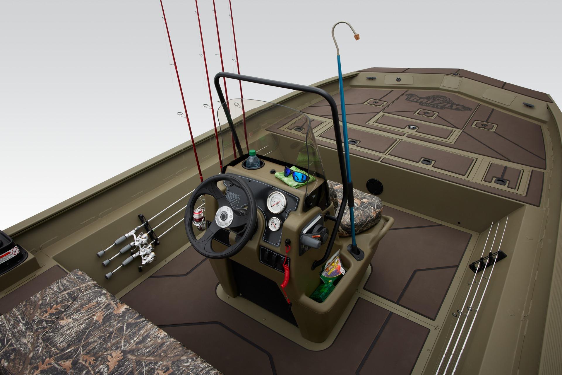 2025 Tracker Grizzly 2072 CC boat interior with fishing rods and steering console.