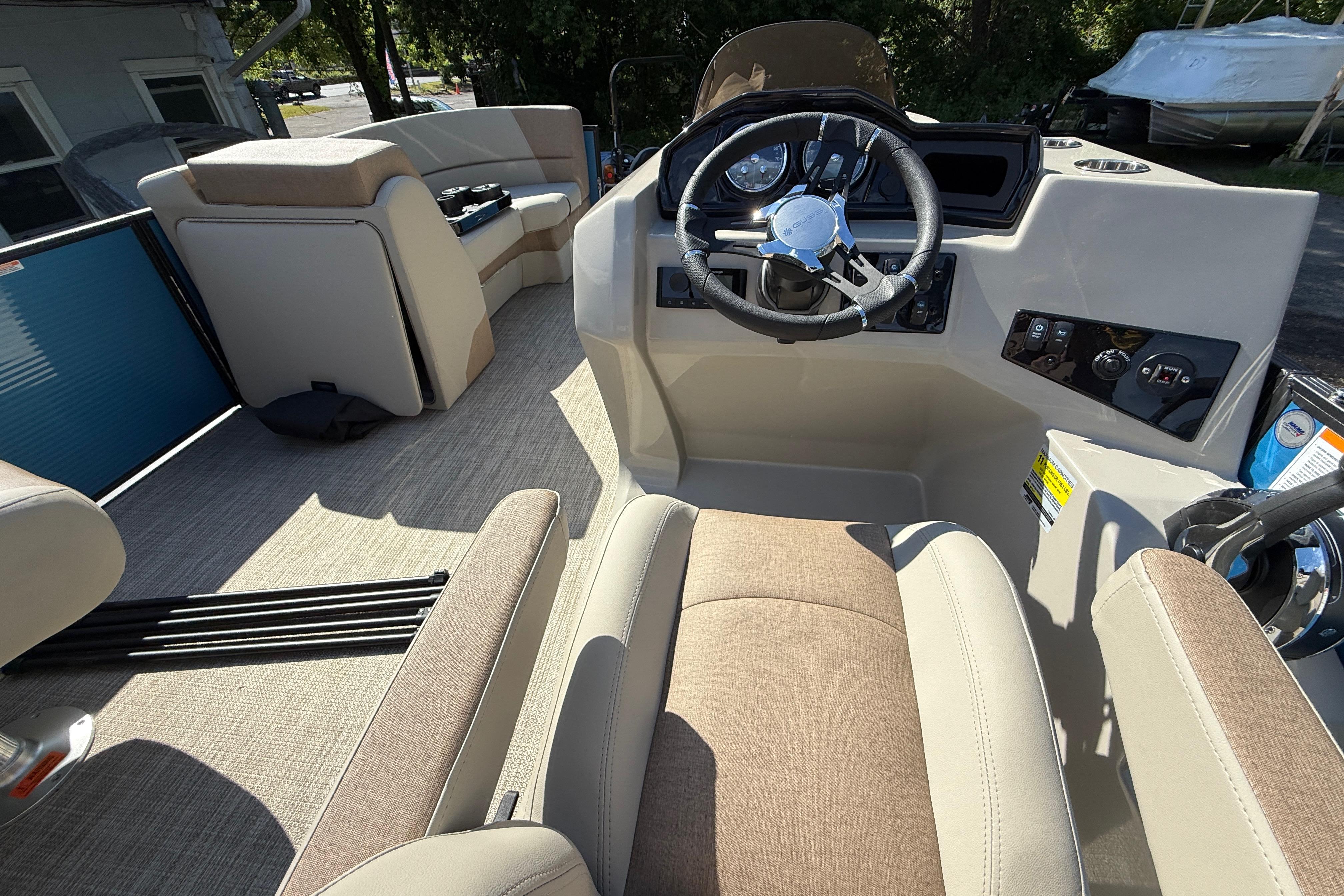 Interior of 2027 Manitou Aurora RF 23 pontoon boat with beige seating and steering console.