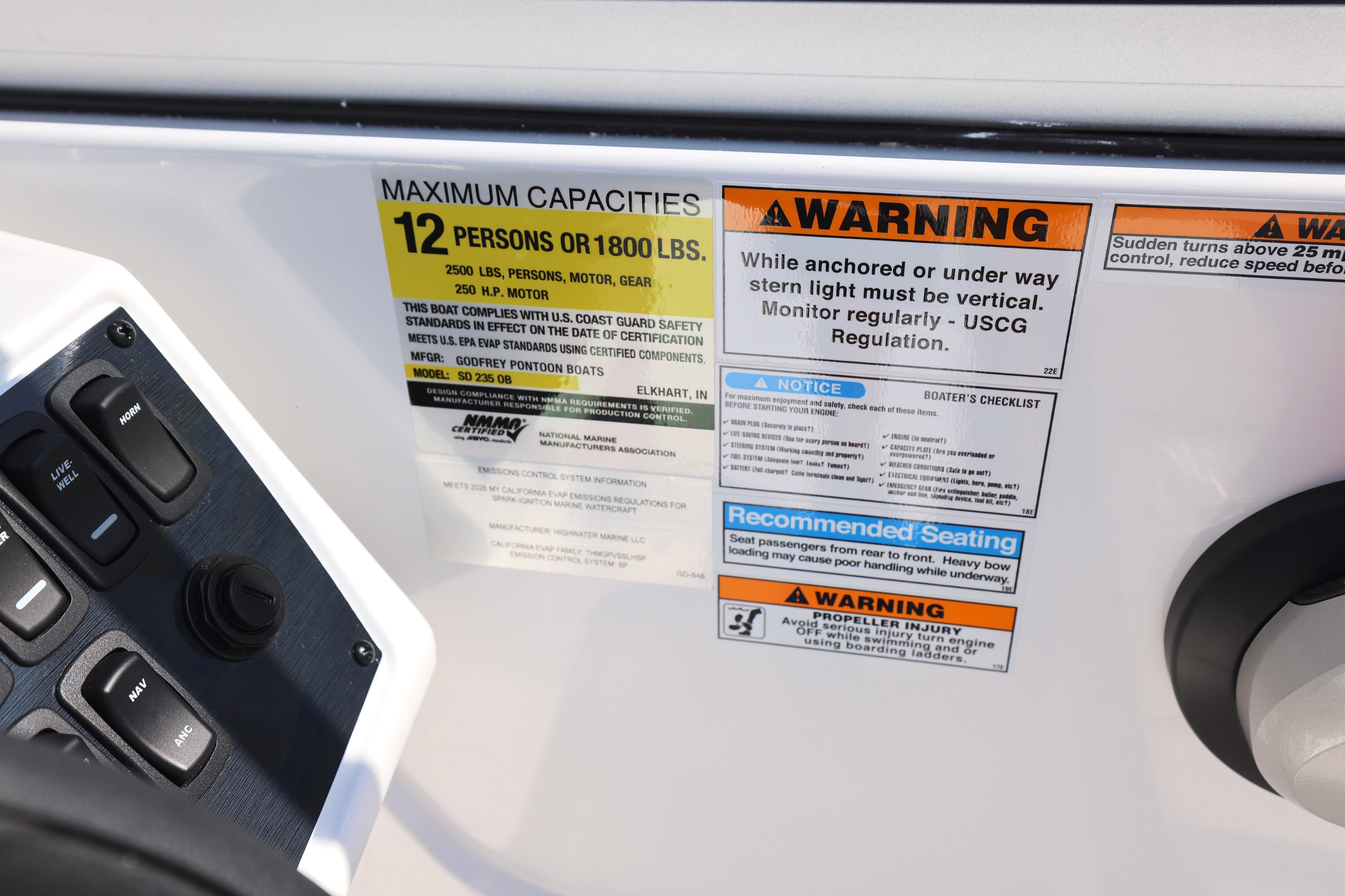 2026 Hurricane SunDeck 235 OB capacity and safety warnings on boat dashboard.