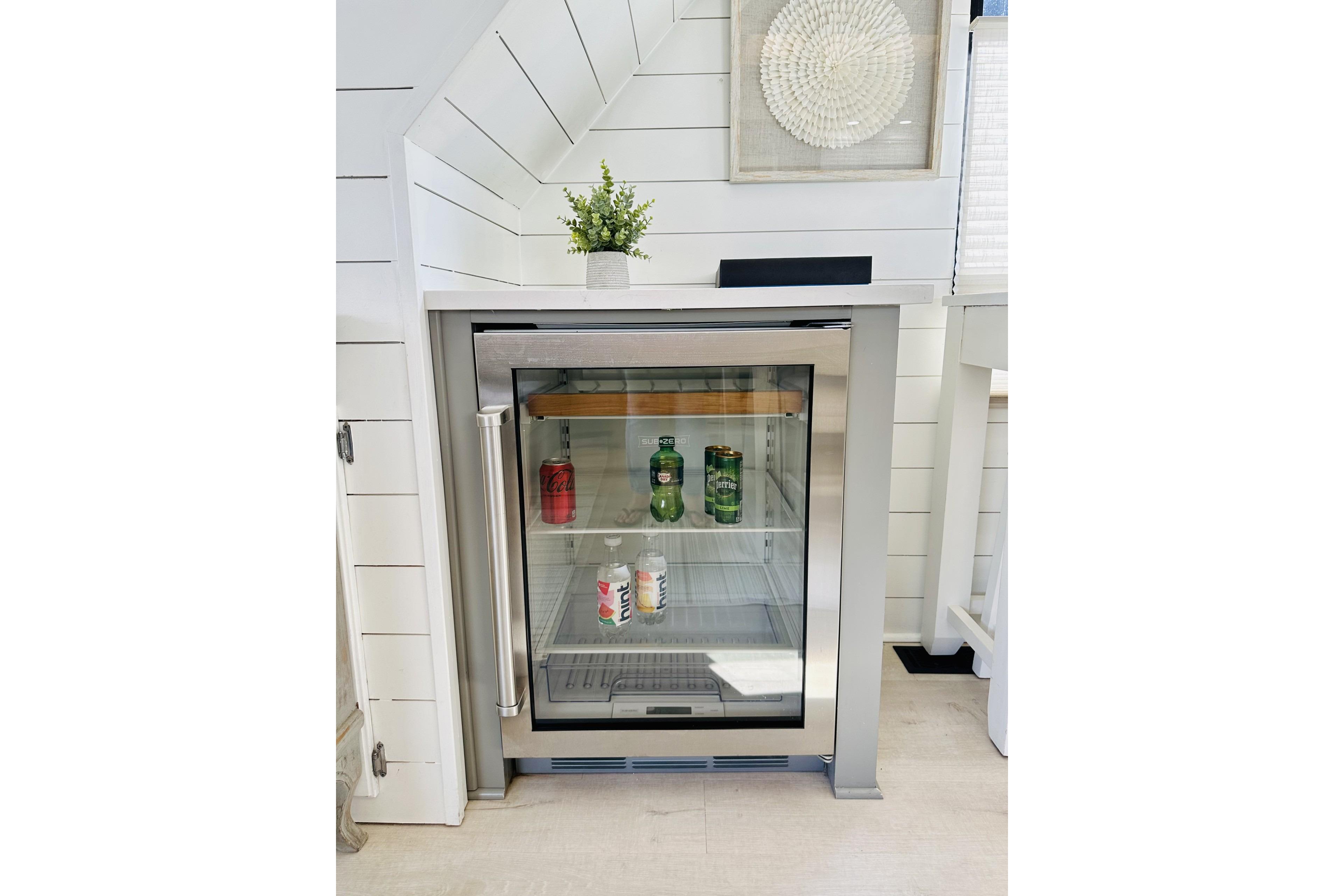 Small beverage fridge with drinks, set in a modern white interior on a Sumerset 66, 1992 model.