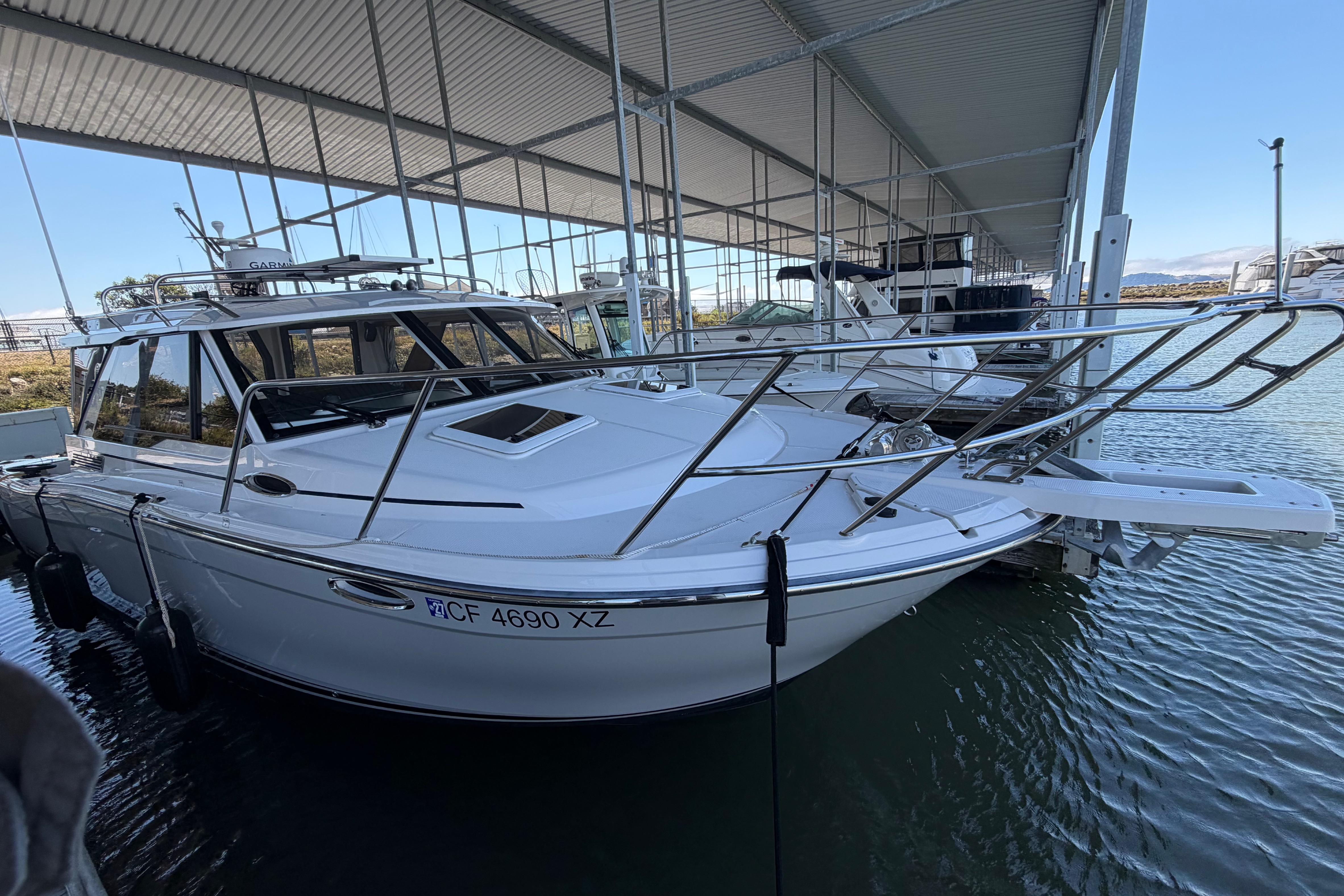 2023 Cutwater C-288 Coupe boat docked under a covered marina.