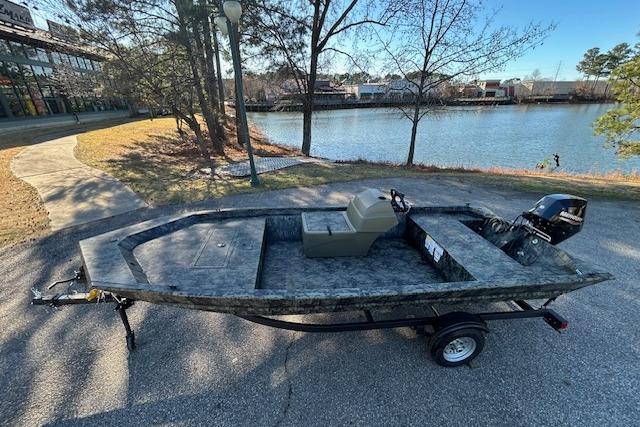 2026 Tracker Grizzly 1648 SC boat on trailer by a lakeside path.