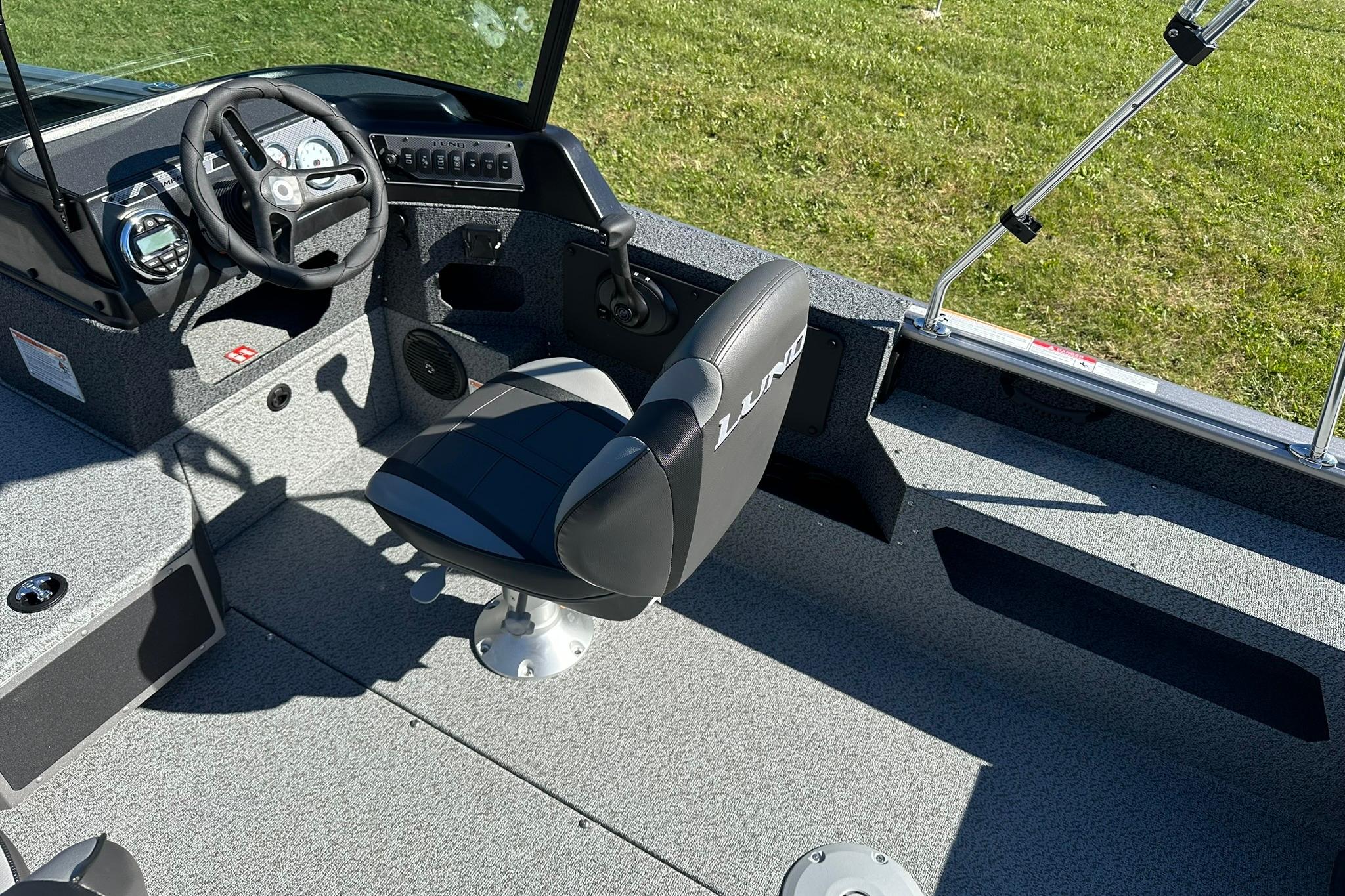 2026 Lund 1875 Impact XS Sport boat interior with steering wheel and seating.