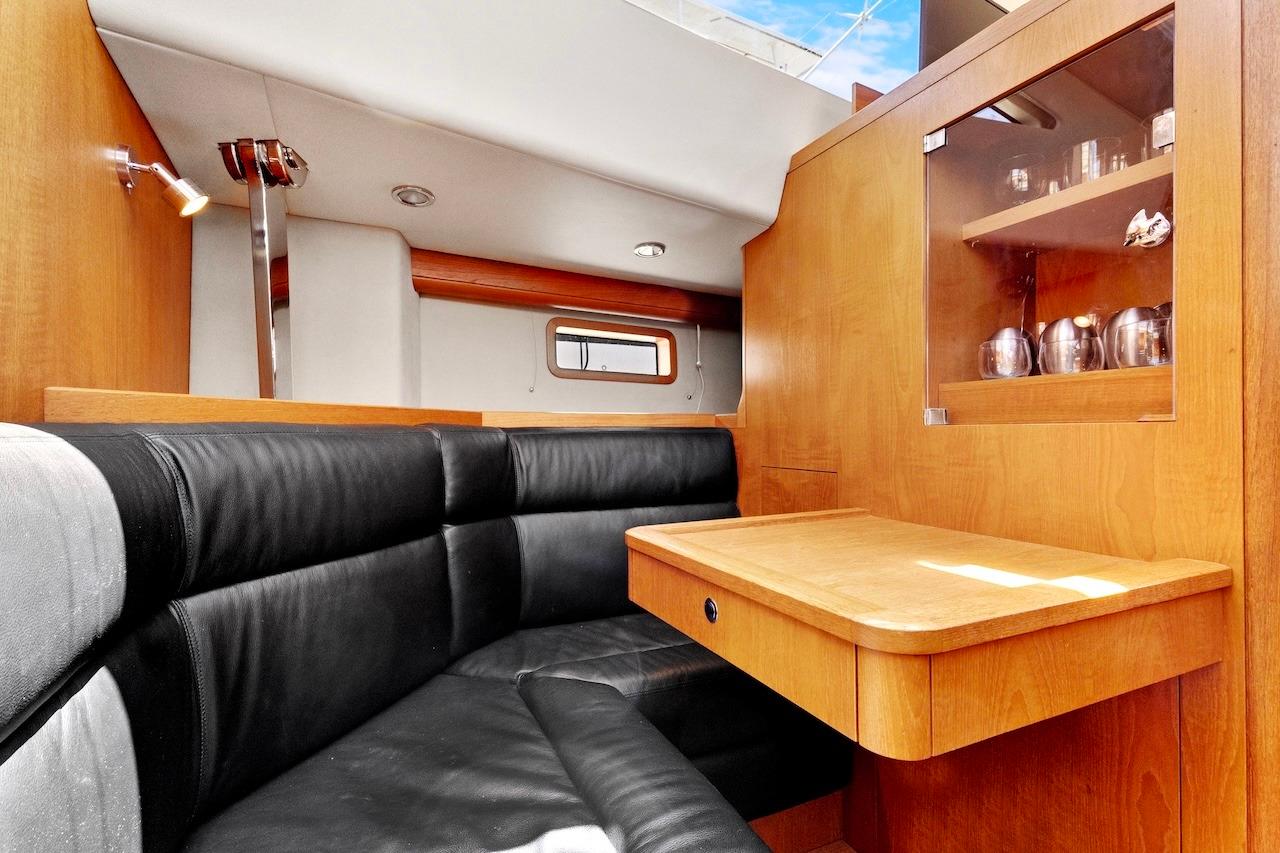 Interior of 2011 Southerly 57 RS yacht with wooden cabinetry and black leather seating.