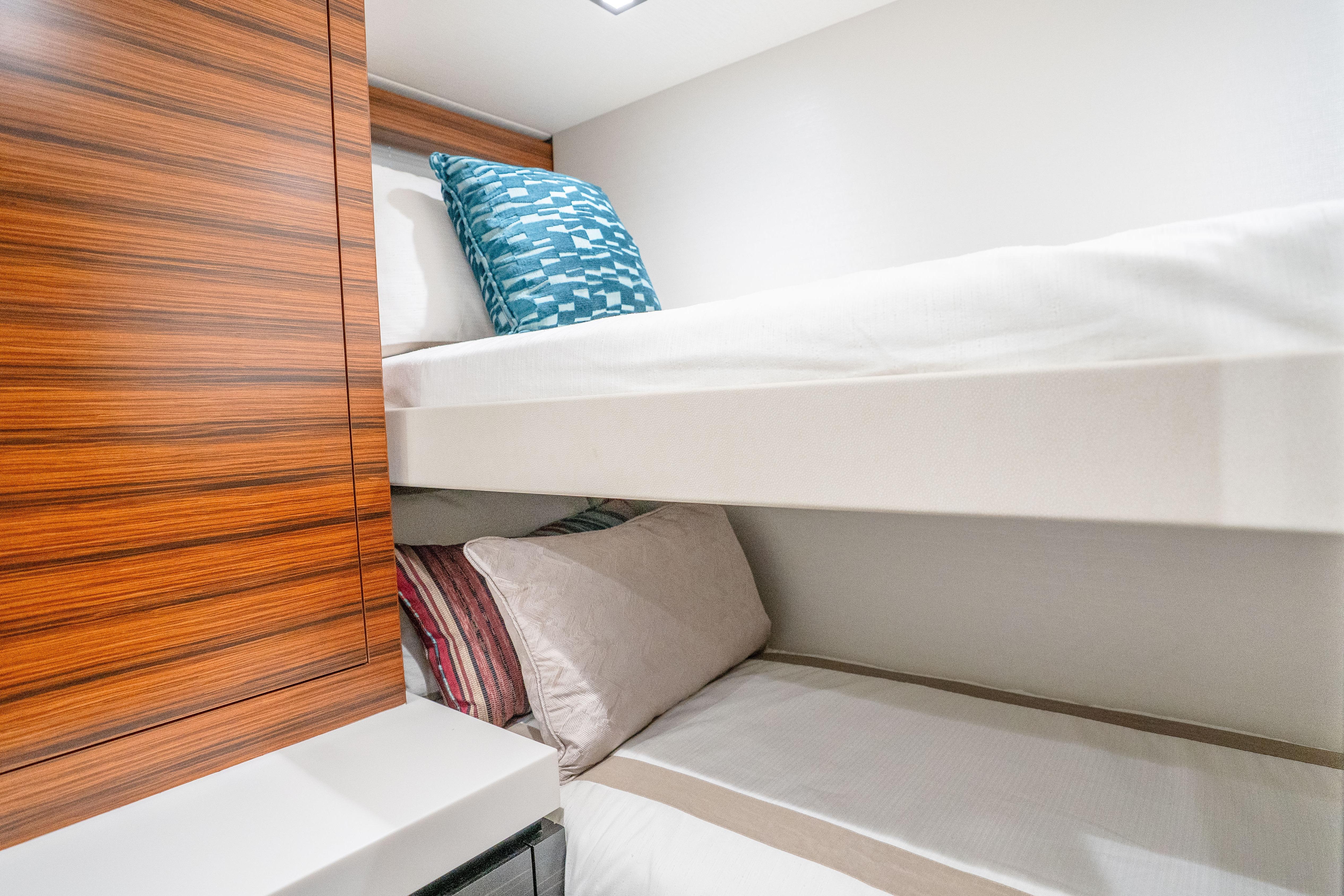 Bunk beds in 2021 Hatteras M75 Panacera yacht cabin with modern wood paneling.