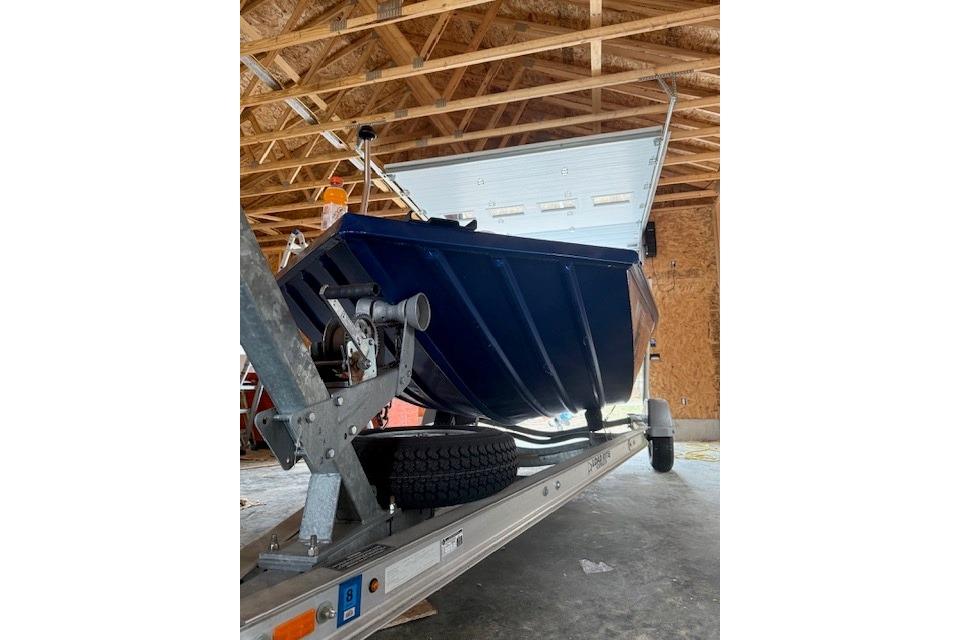 2018 Alumacraft Pro 185 boat on trailer in garage, viewed from below.