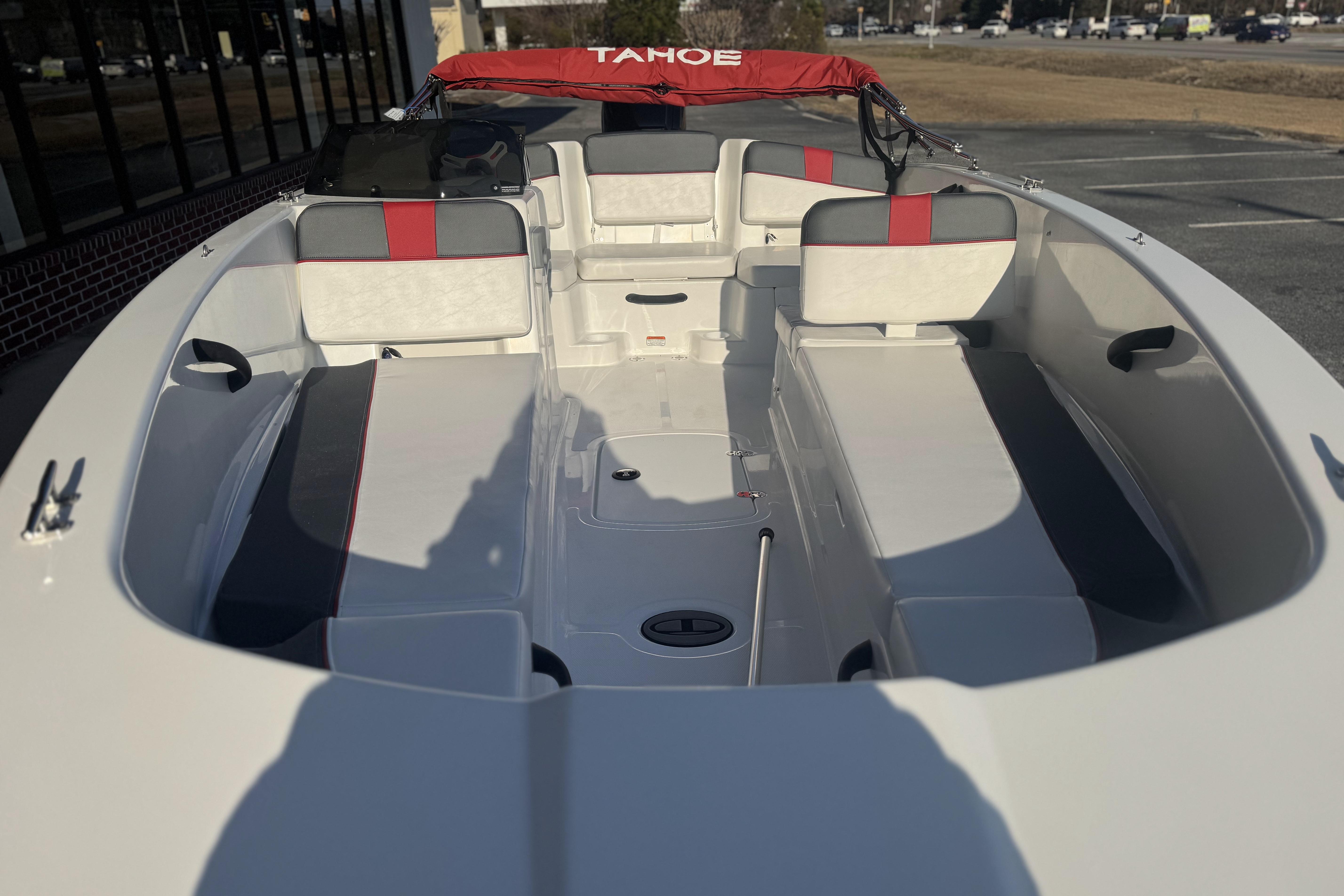 2026 Tahoe T18 boat interior with red and gray seating, docked outdoors.