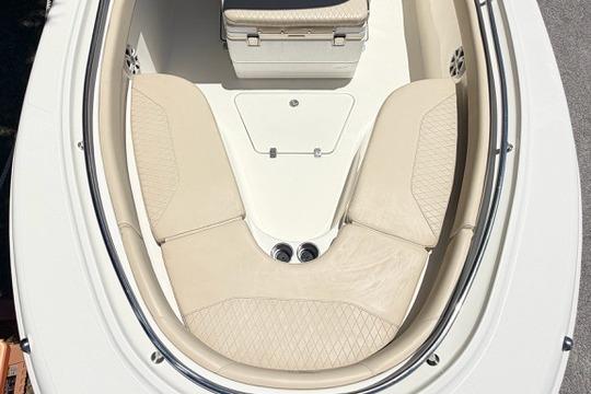 2011 Pioneer 222 Sportfish boat with beige seating and storage area.