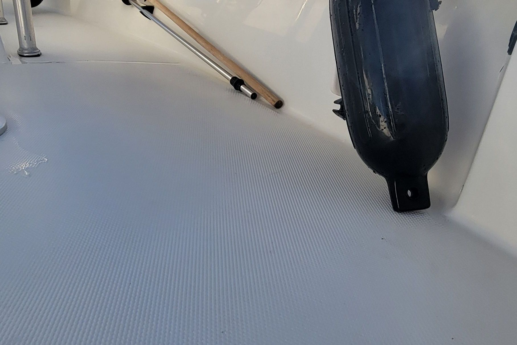 Close-up of a Mako 184 Center Console boat deck with a fender and paddle.