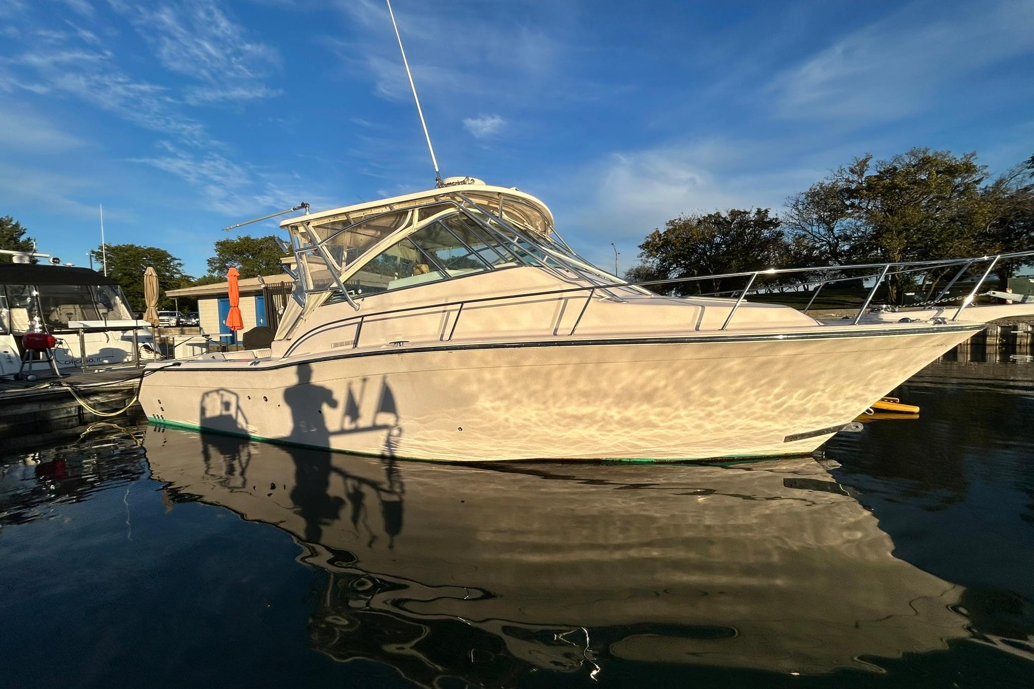 2007 Grady-White Express 360 boat docked on calm water under a clear blue sky.
