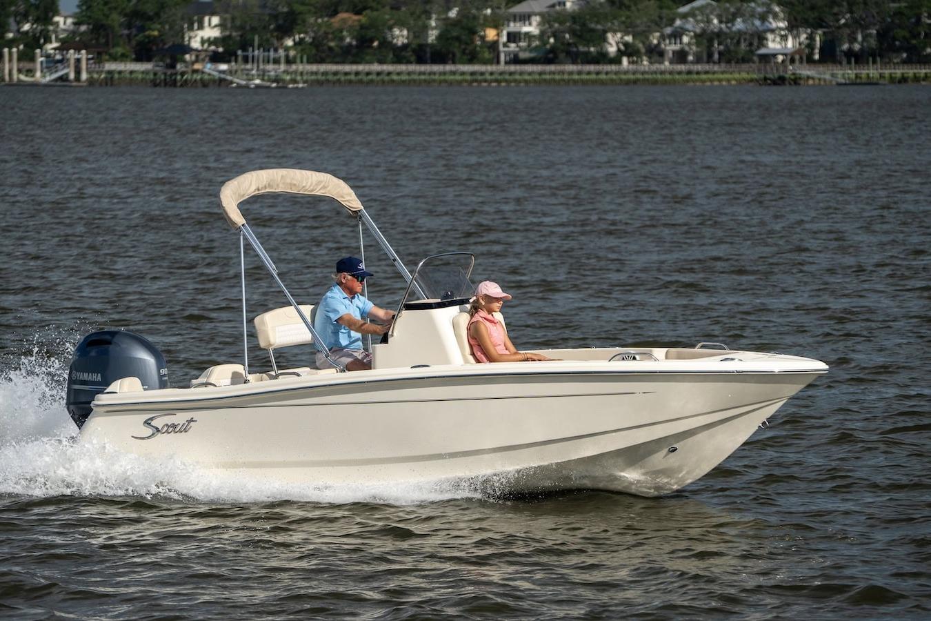 2026 Scout 188 Sportfish boat cruising on a calm lake with two passengers.