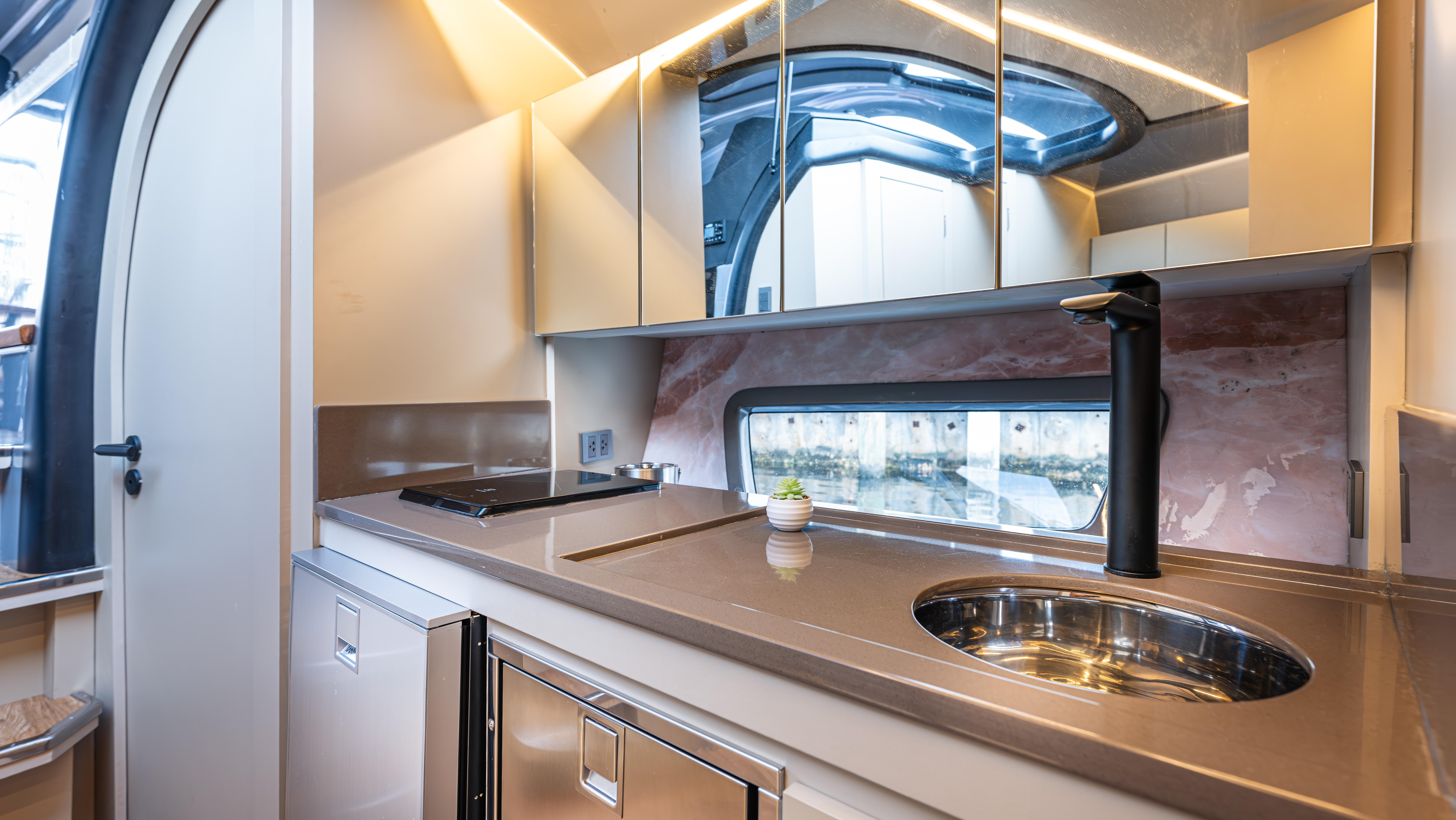Modern kitchen interior in 2025 Hanover 415 RV, featuring sleek design and compact appliances.