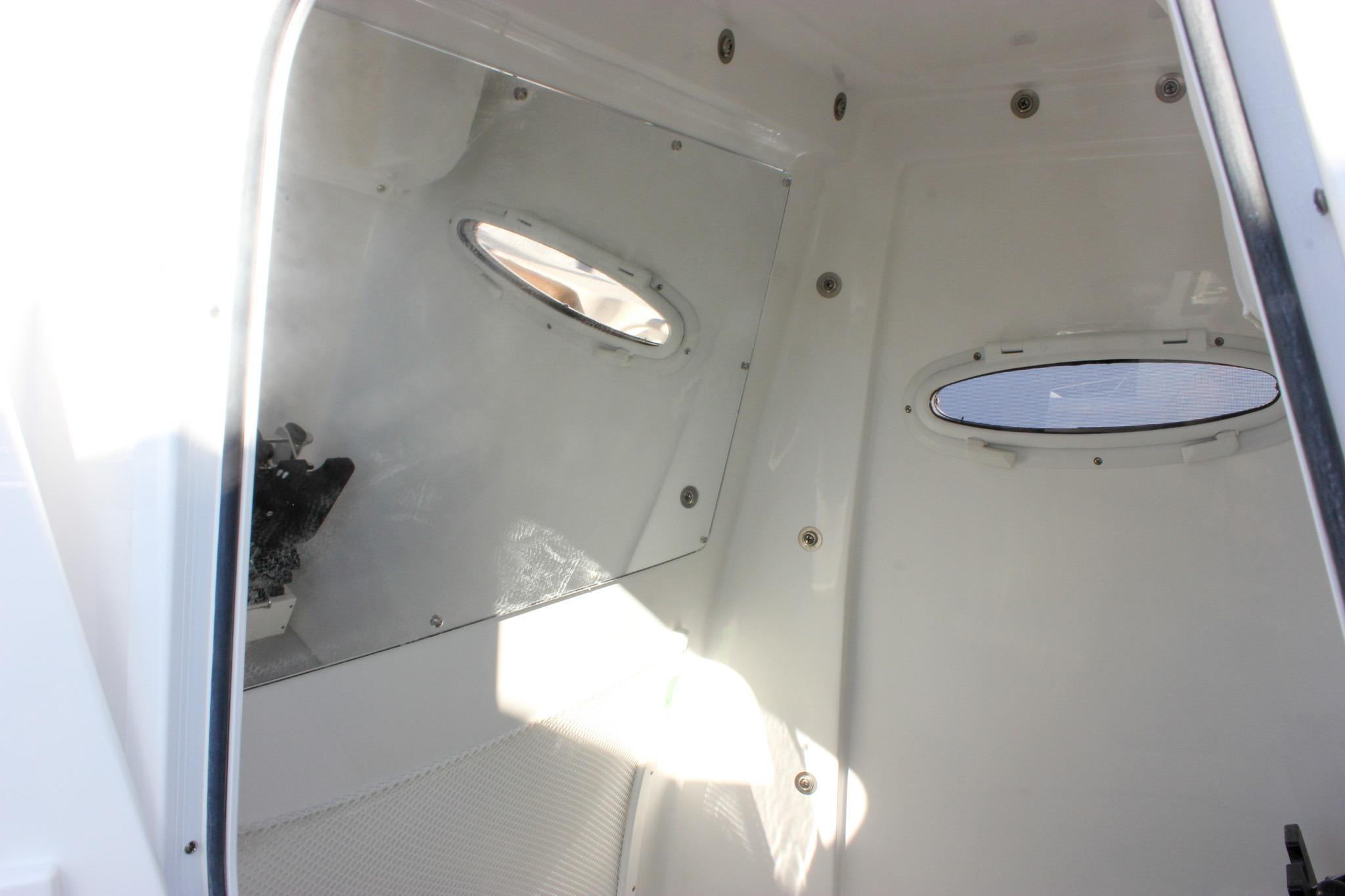 Interior cabin of 2026 Sea Hunt Ultra 285 SE boat with oval windows.