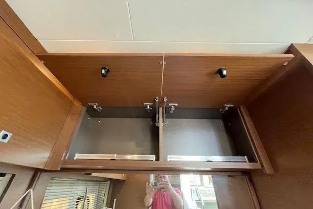 Open wooden cabinet inside 2016 Sea Ray Sundancer 510 yacht, showcasing interior storage space.