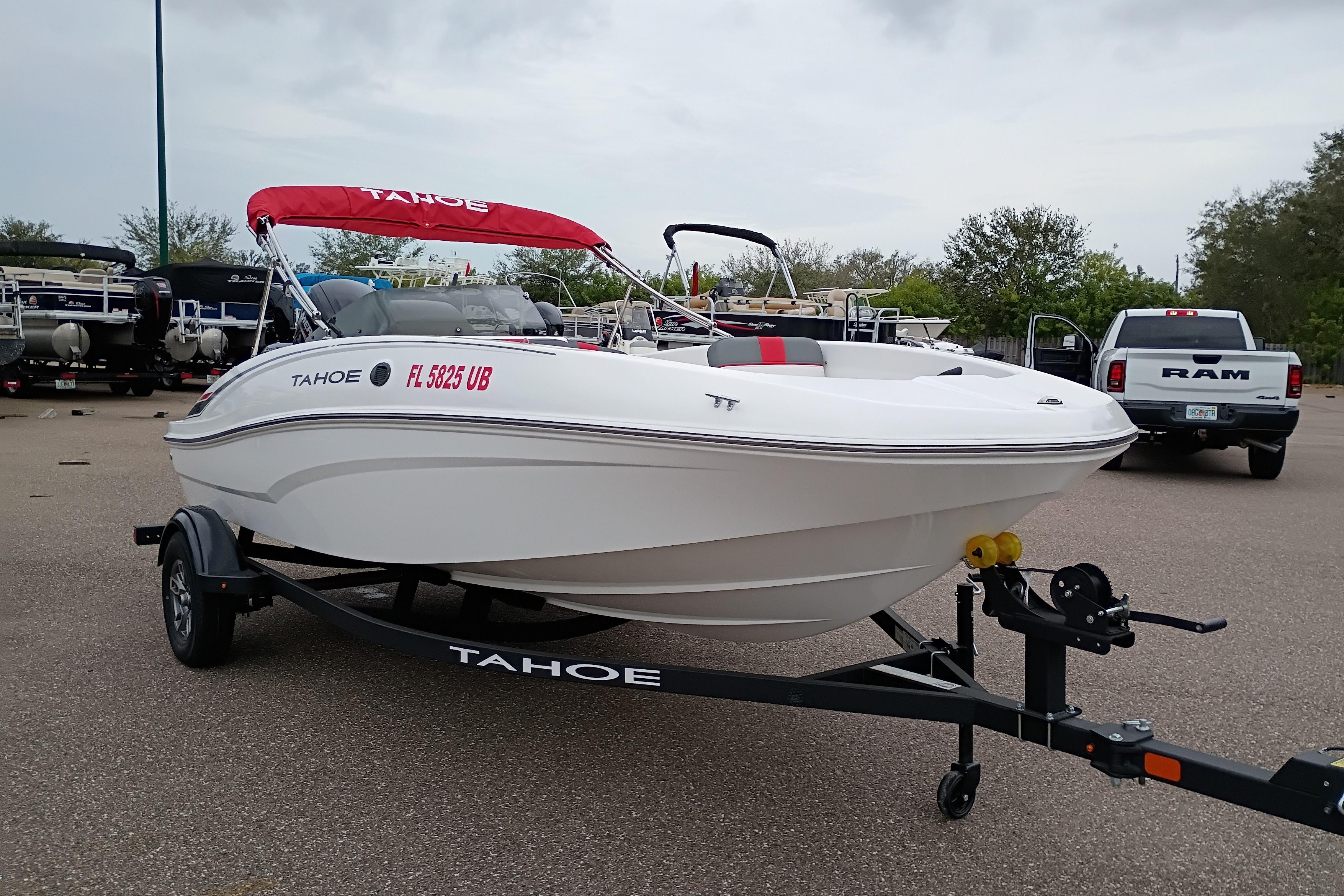 2026 Tahoe T16 boat on trailer with red canopy in parking lot.