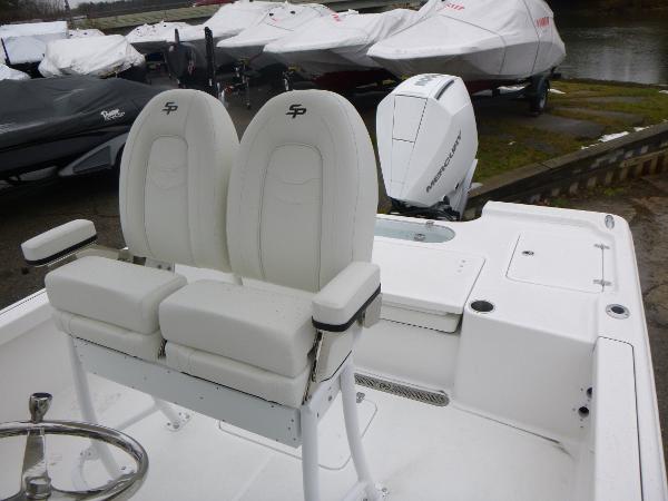 2025 Sea Pro 250 Bay boat with dual seats and outboard motor, docked near covered boats.
