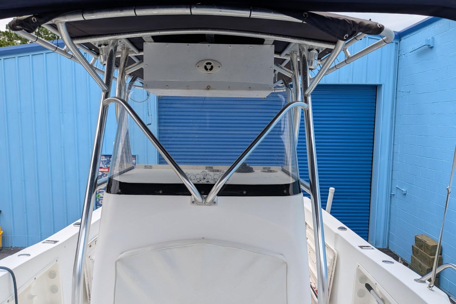 2002 Pro Sports 2200 CC ProKat boat with T-top and blue storage doors.
