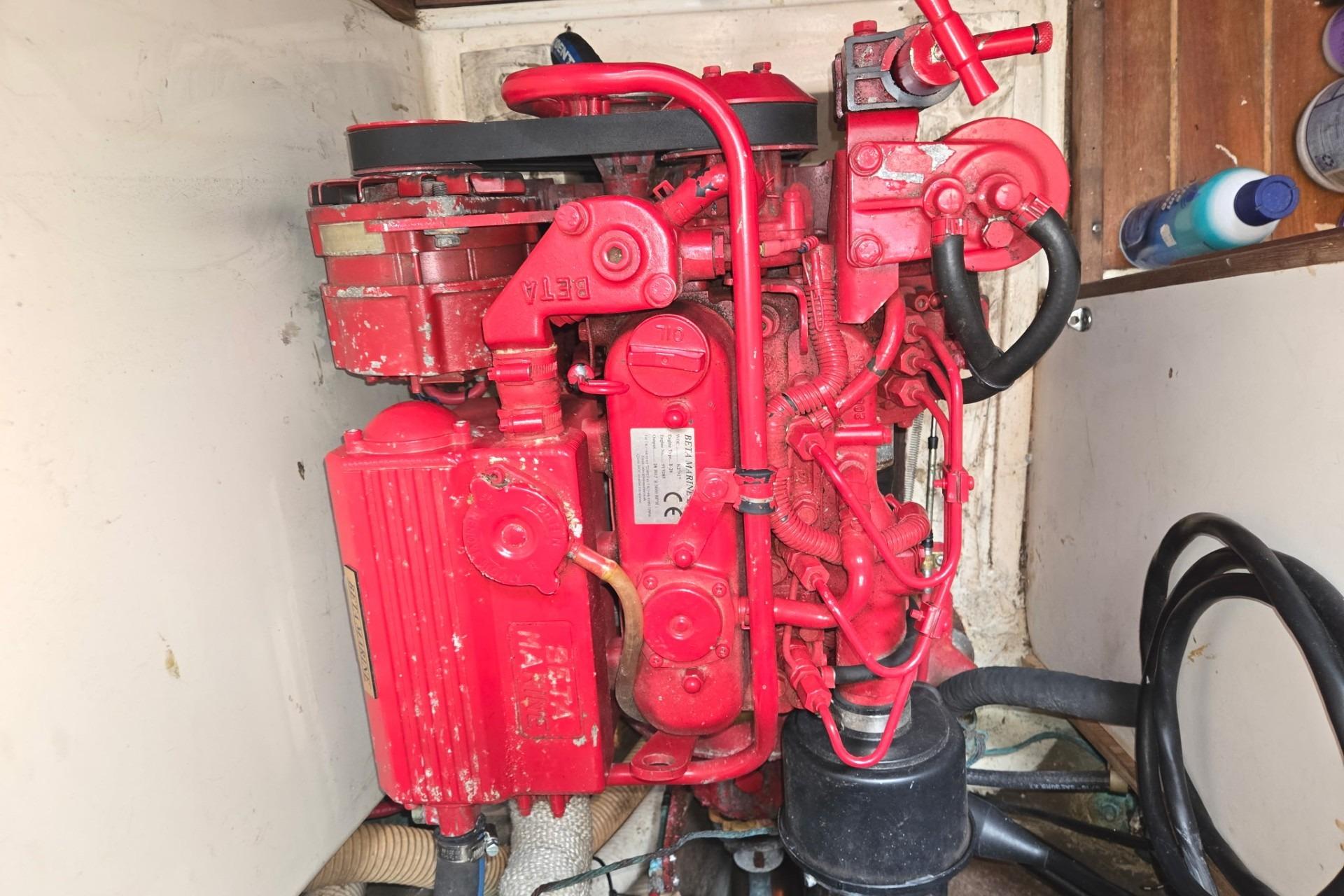 Red engine inside a 1981 Sea Sprite 34 sailboat, showcasing mechanical components.