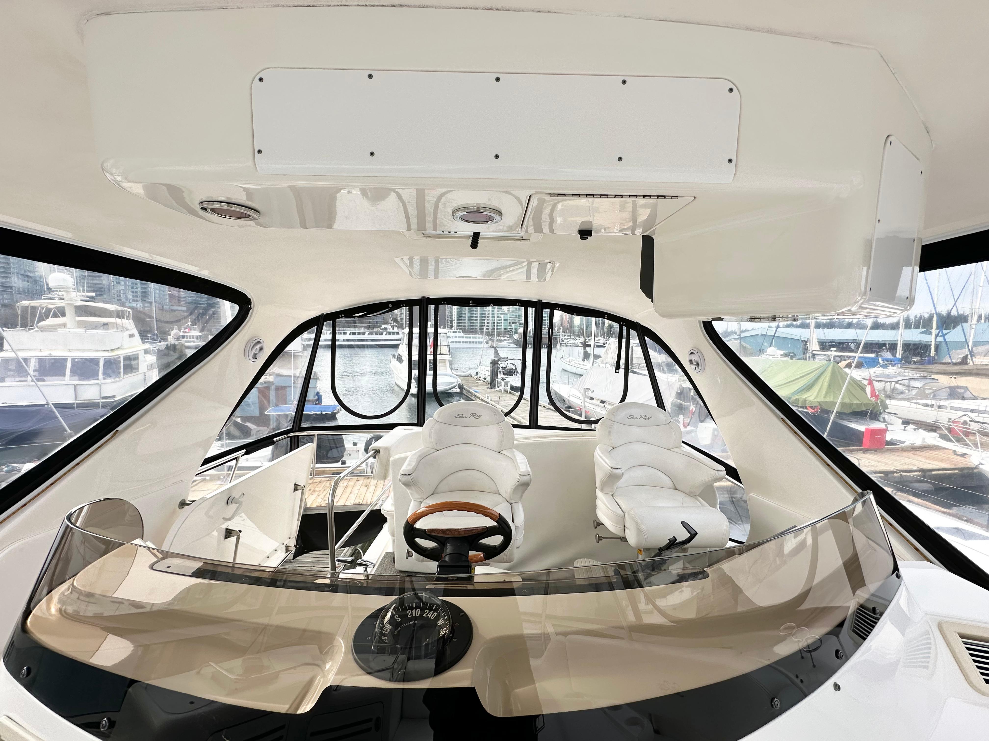 Interior view of 2002 Sea Ray 560 Sedan Bridge yacht cockpit with helm and seating.
