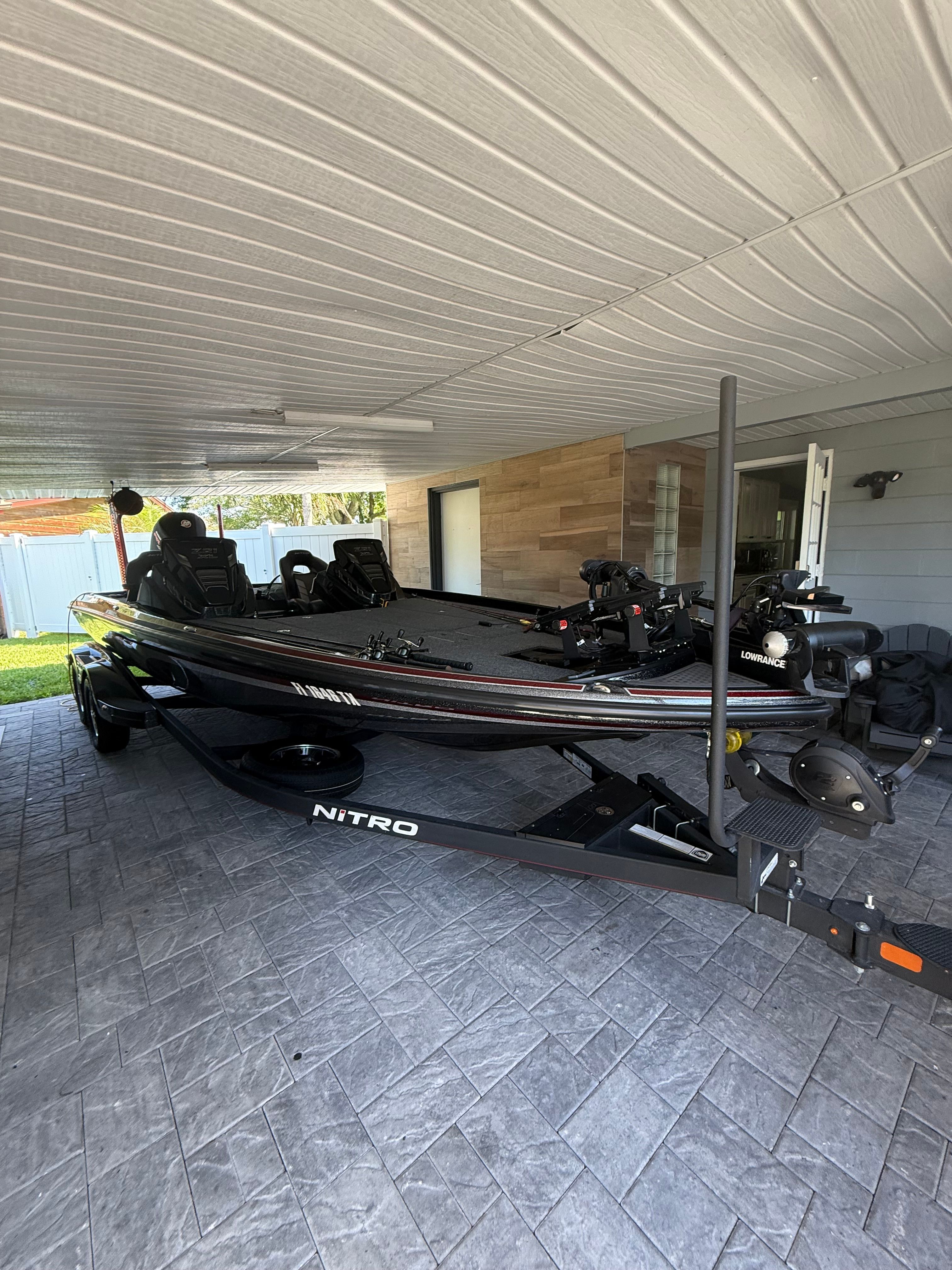 A 2024 Nitra Boats 21 XL Pro on a trailer under a covered area.