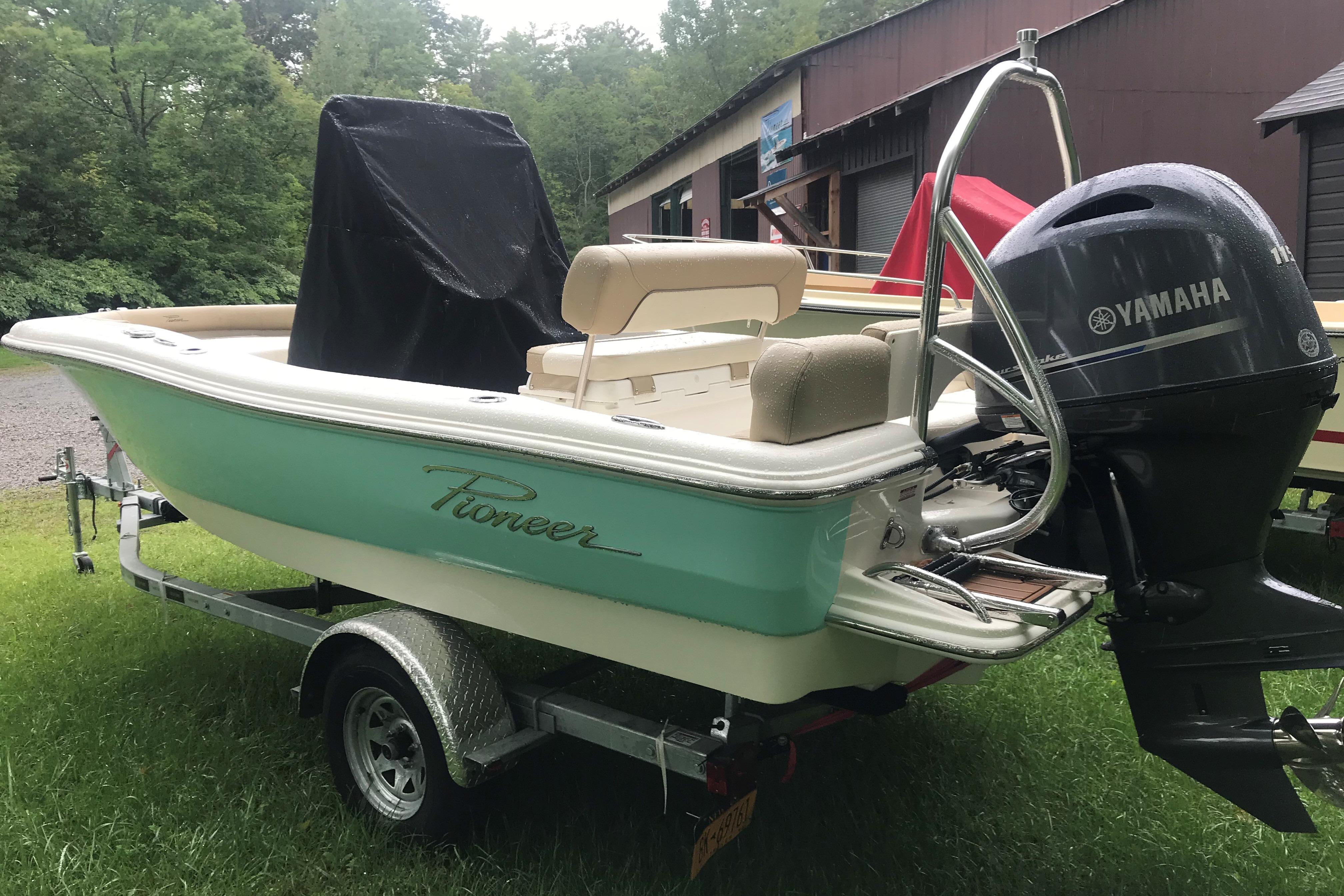 2026 Pioneer 180 Islander boat with Yamaha motor on trailer, parked on grass.