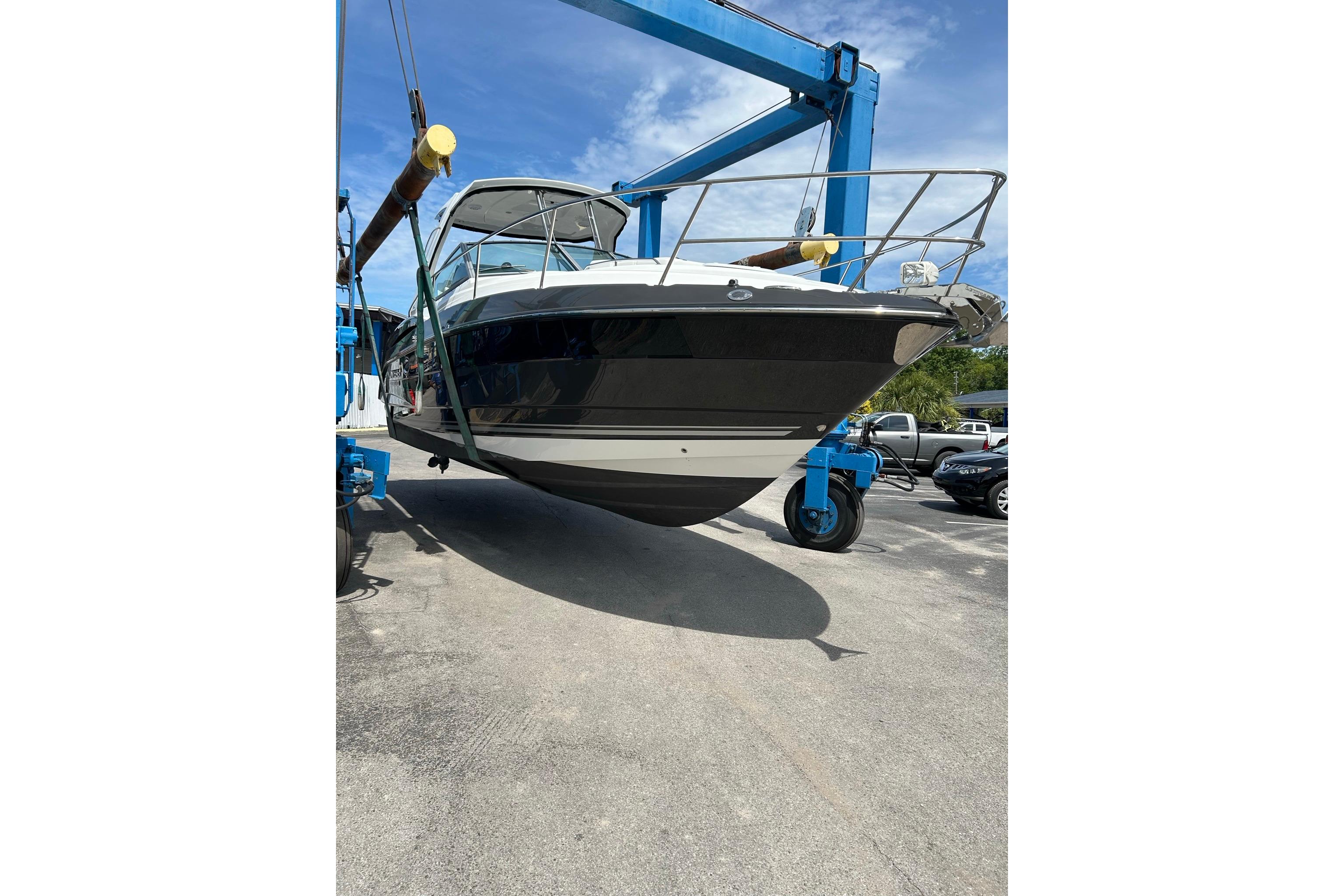 2019 Monterey 335 Sport Yacht lifted by blue crane under clear sky.