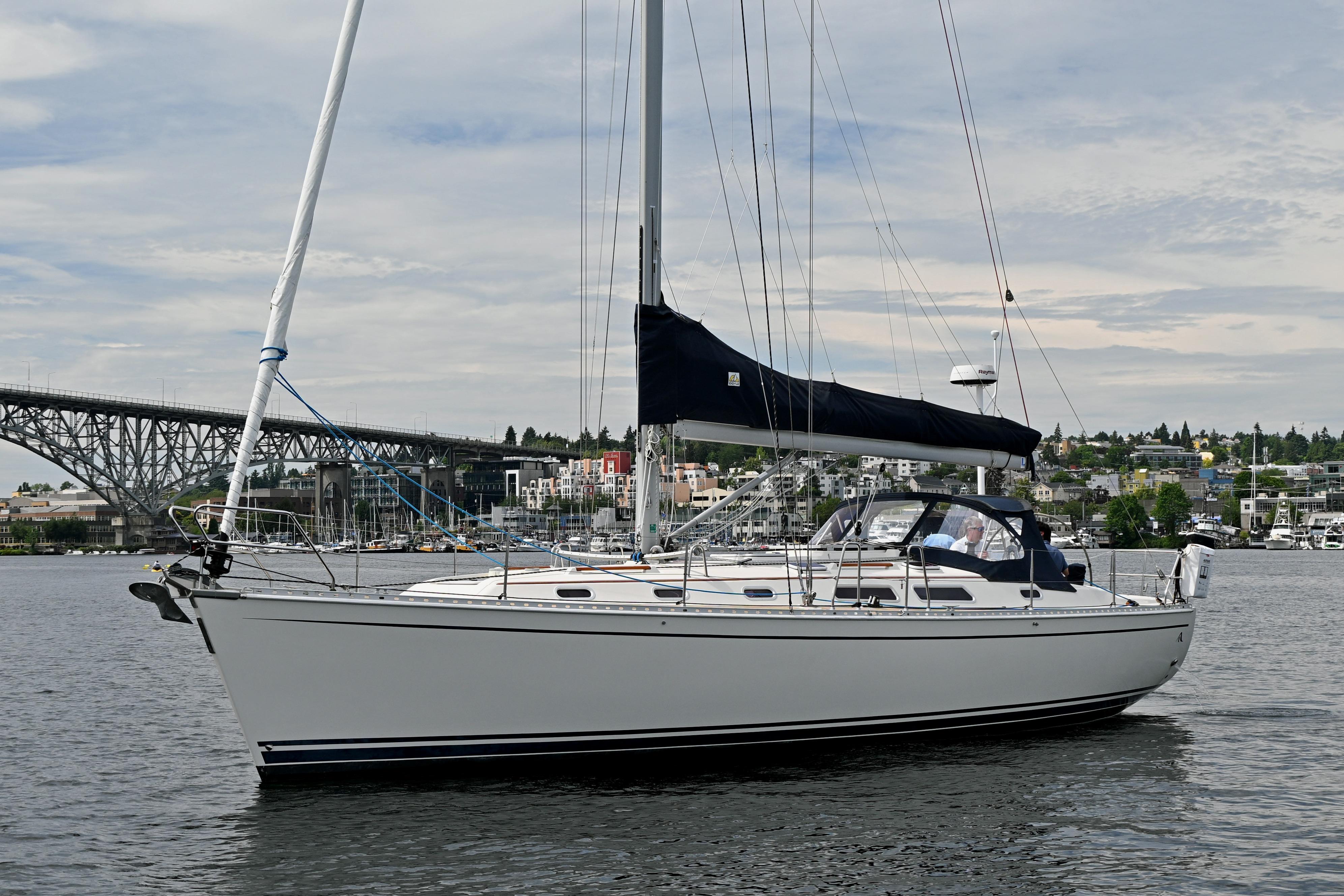 2004 Hanse 411 sailboat on calm water near a bridge and cityscape.