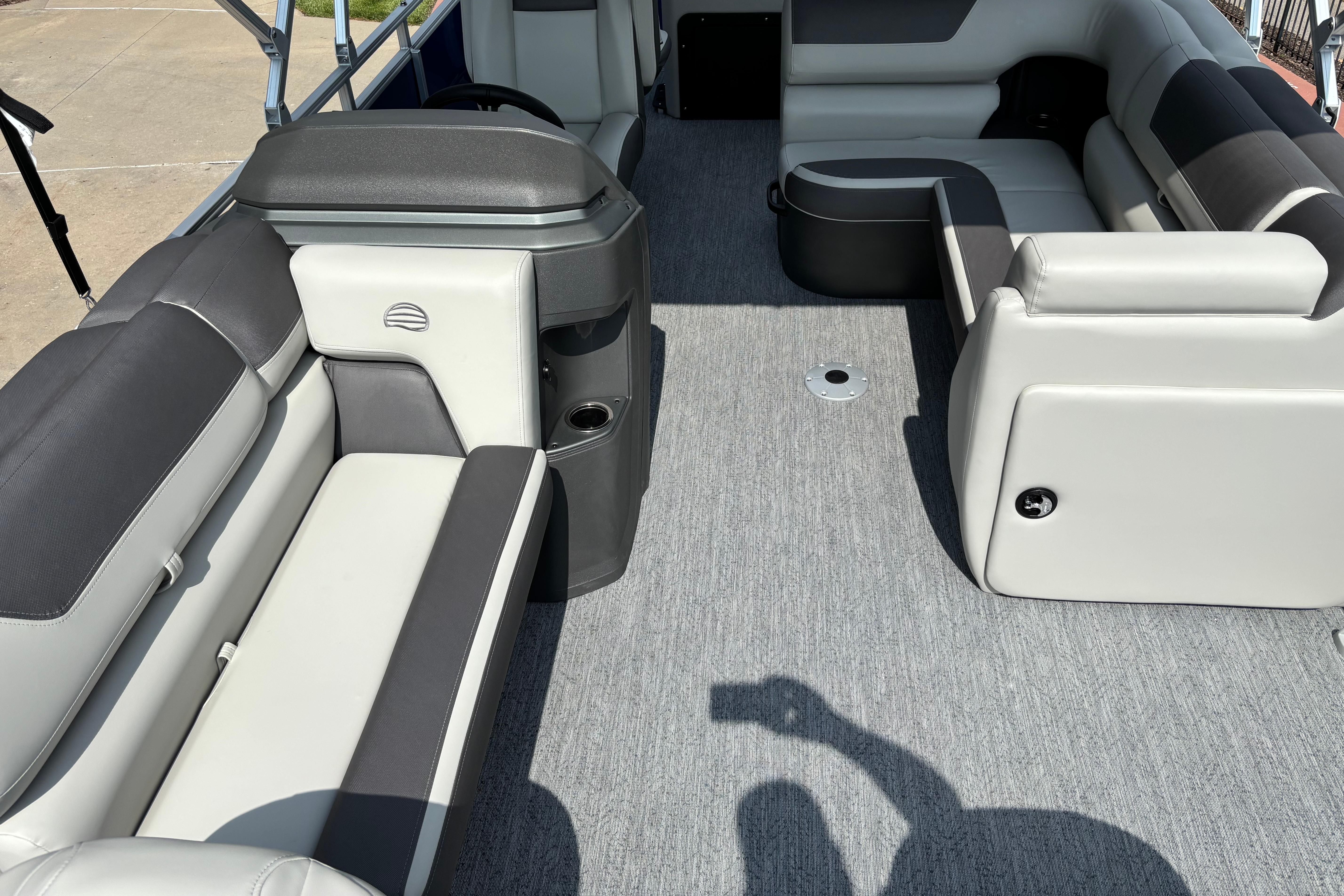 2026 Sun Tracker Fishin' Barge 20 DLX interior with gray seating and carpeted floor.