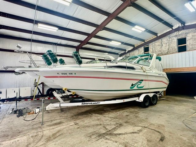 A 1992 Sea Ray 290 Sundancer on a trailer inside a storage facility.