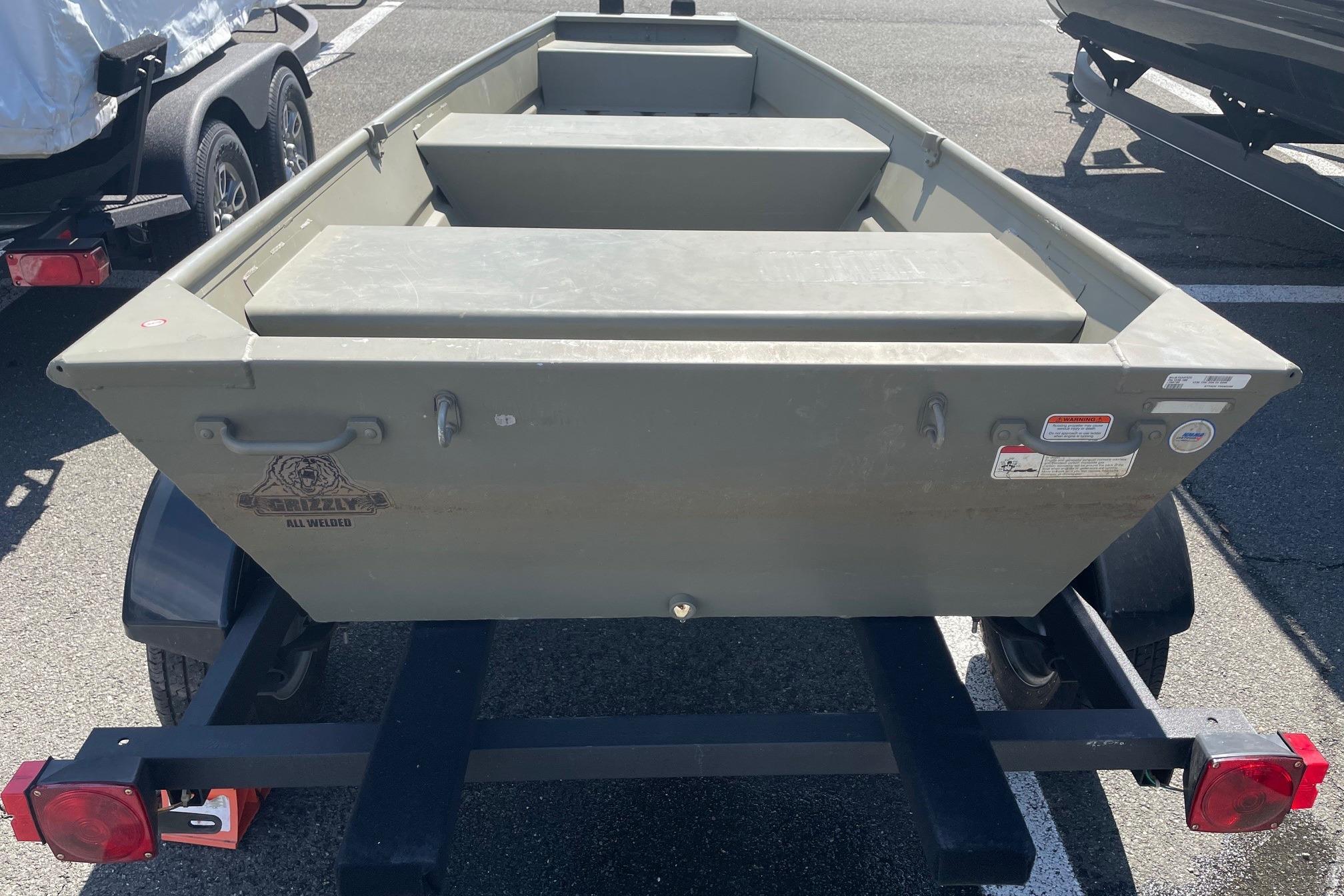 2025 Tracker Grizzly 1236 Jon boat on trailer, parked outdoors.