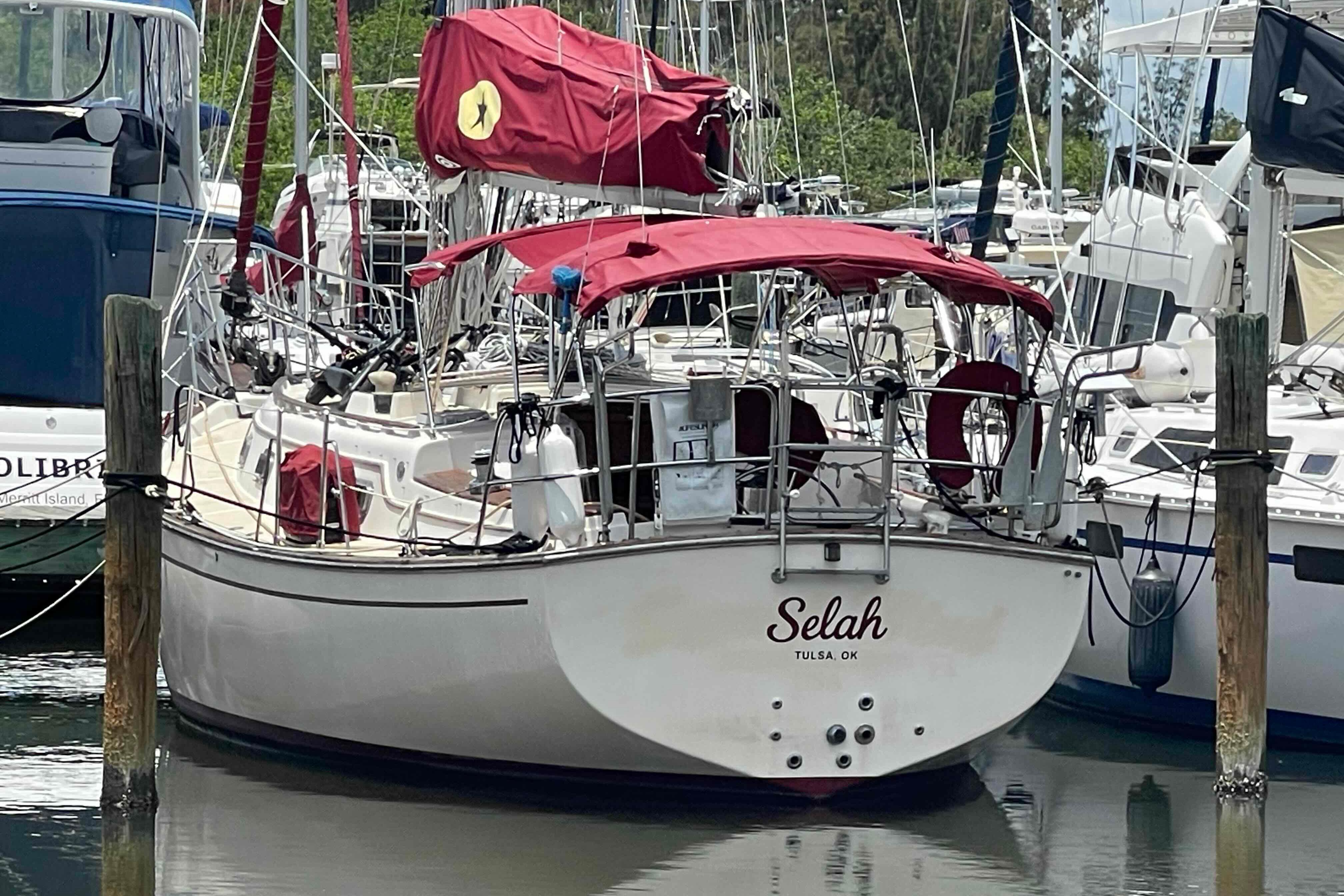 1989 Island Packet 35 sailboat docked in marina, featuring red covers and equipment.
