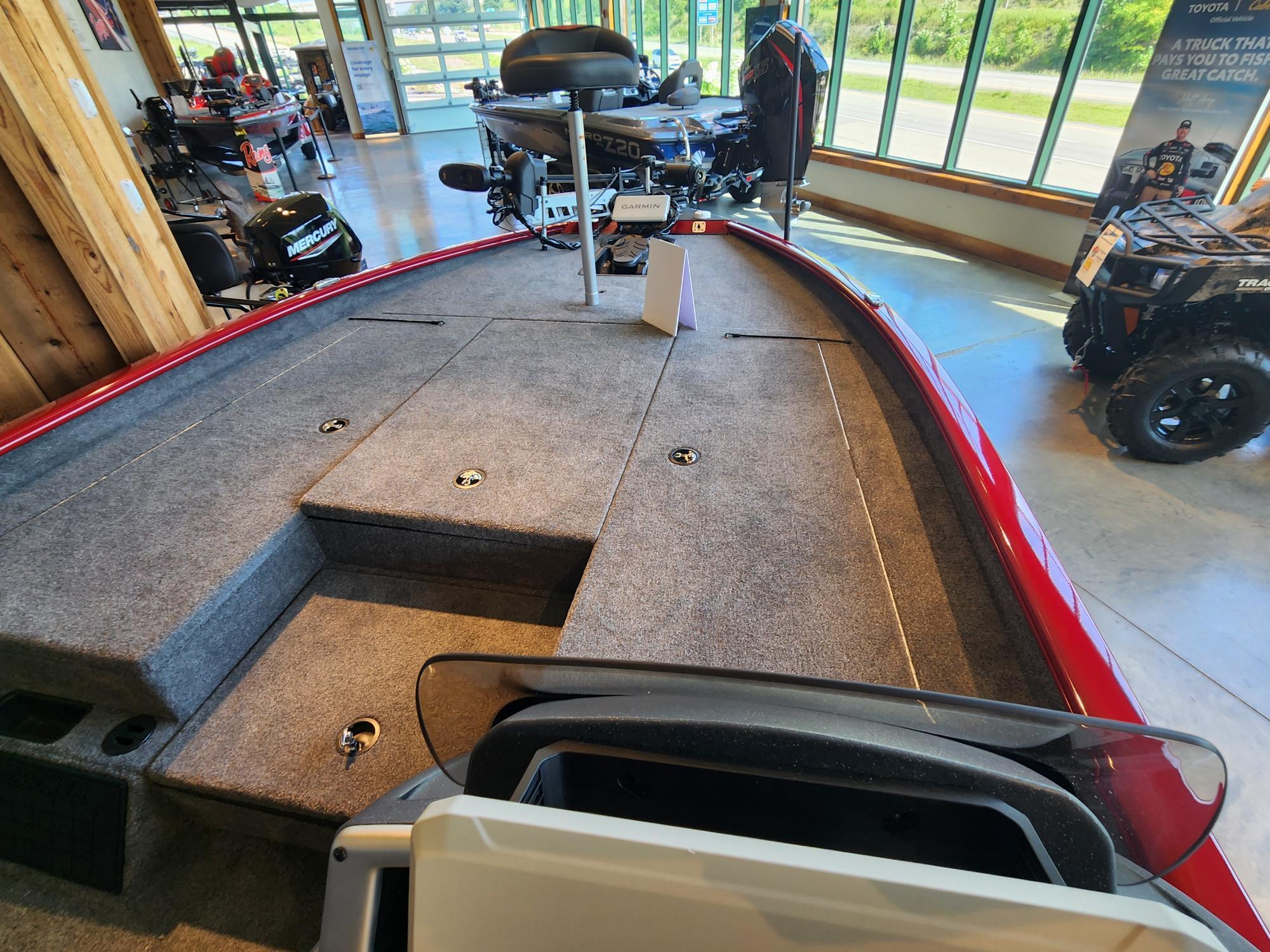 2025 Tracker Savage 215 boat interior with carpeted deck in showroom.