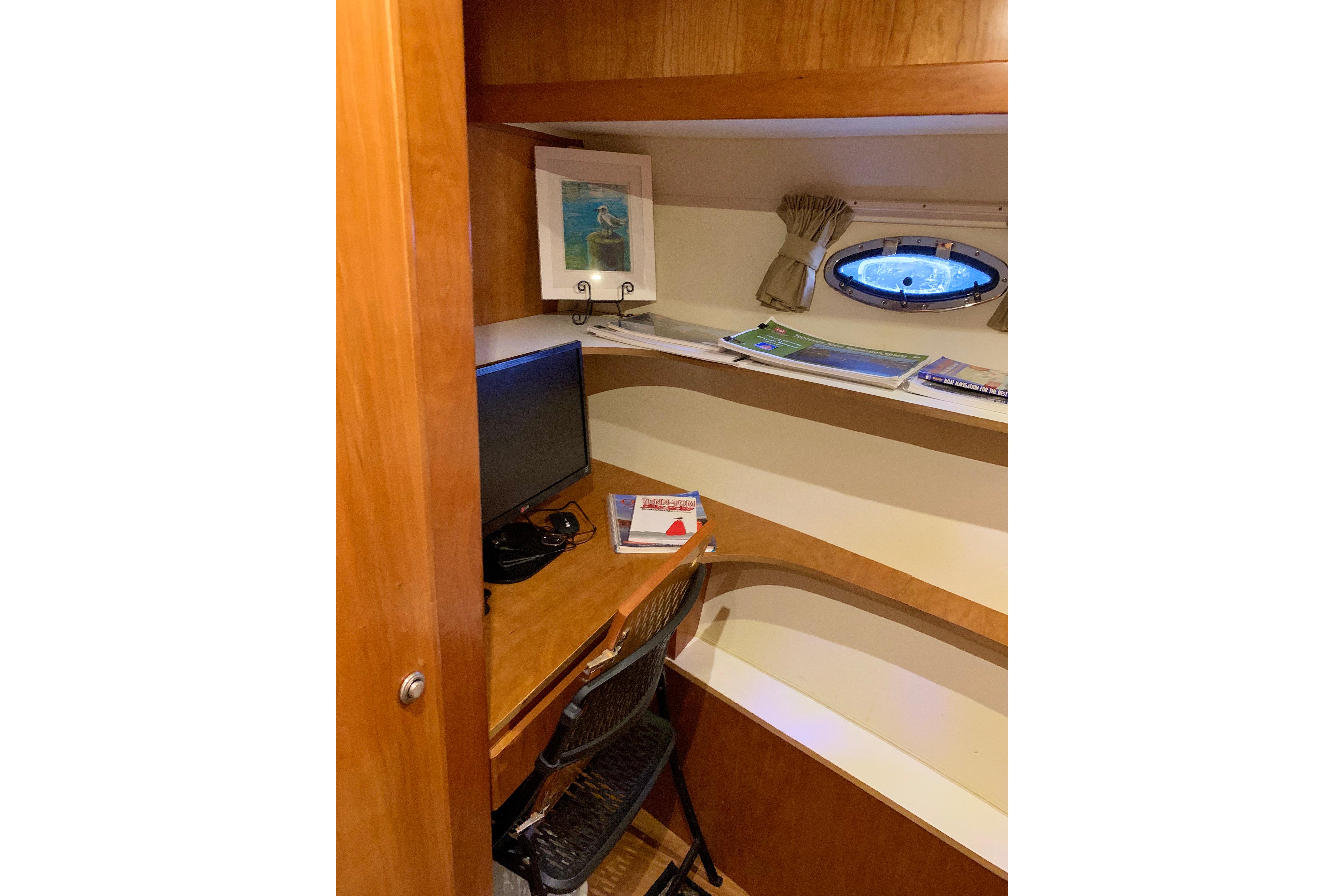 Small office space on 2007 Navigator 5100 yacht with desk, chair, and window.