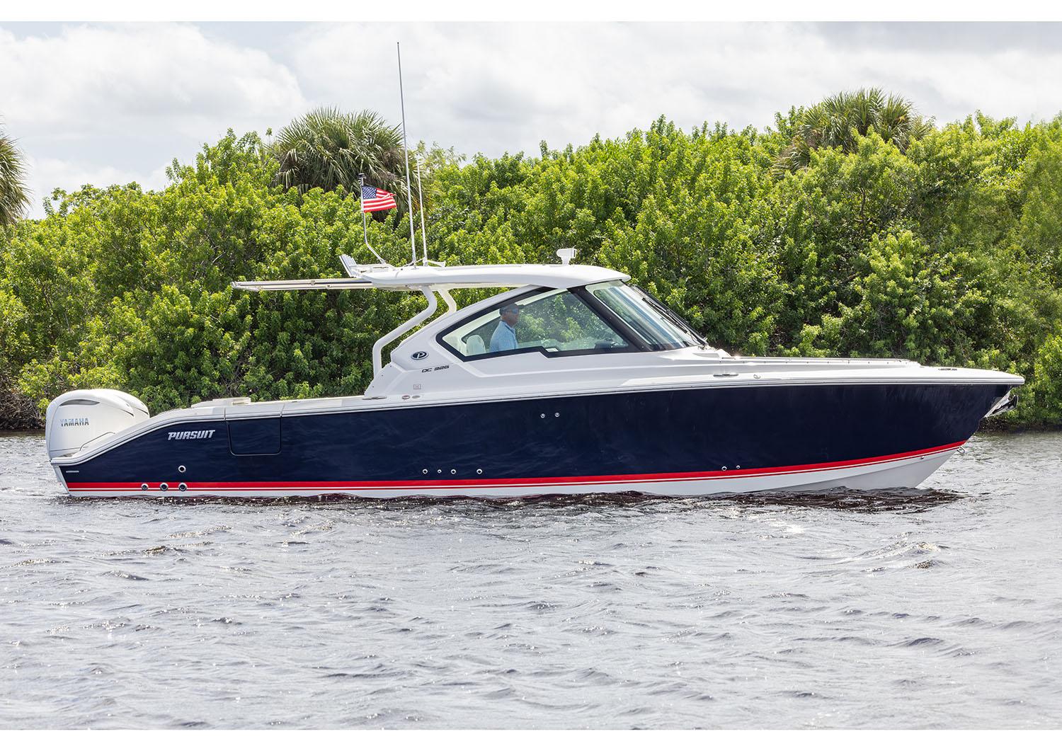 Manufacturer Provided Image: 2025 Pursuit DC 326 Dual Console boat on water, lush greenery background.