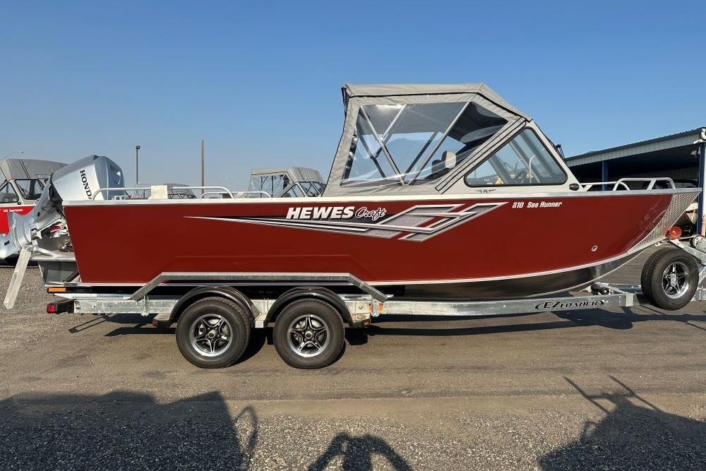 2025 Hewescraft 210 Sea Runner ET boat on trailer, red exterior, side view.