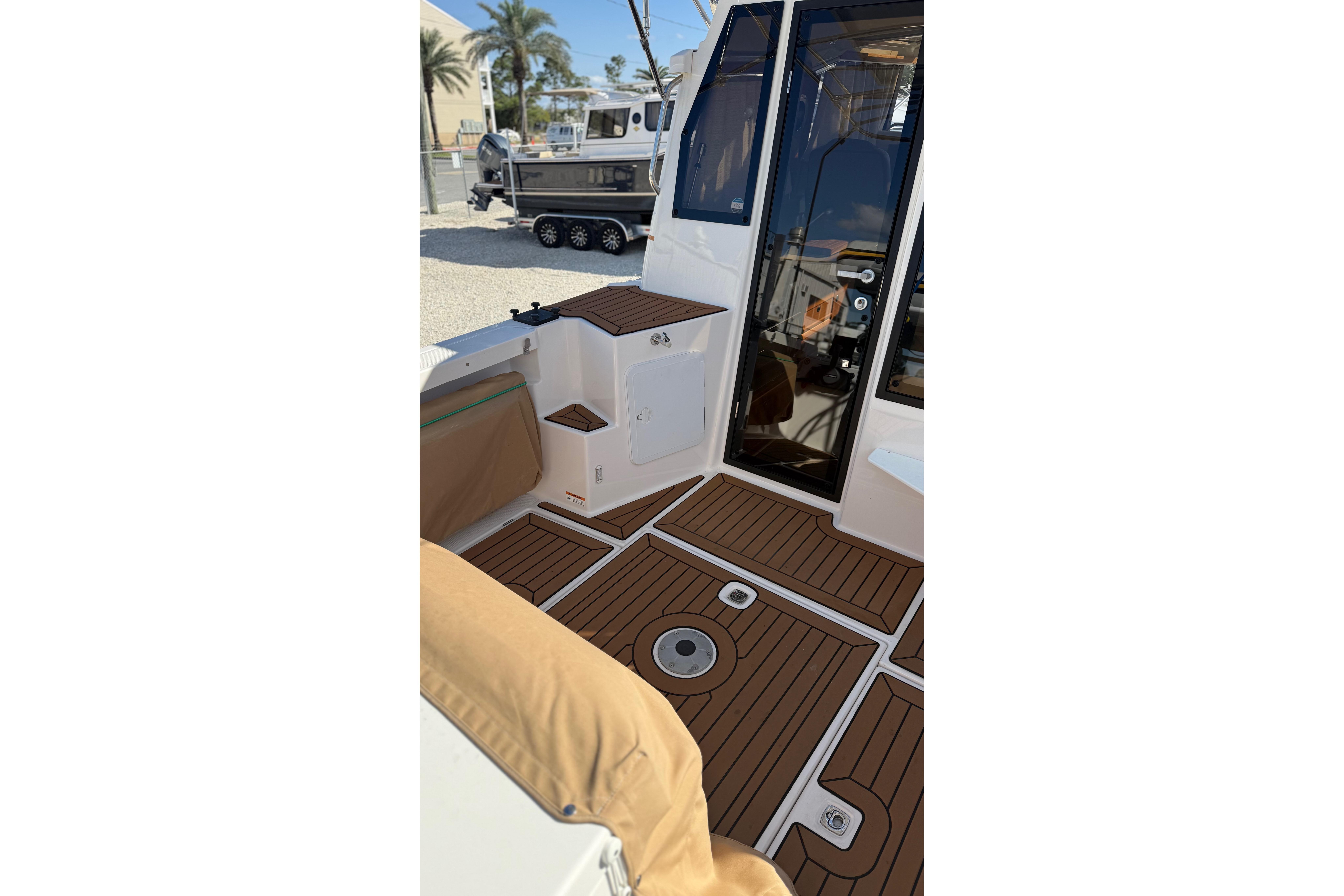2024 Ranger Tugs R-27 boat interior with teak flooring and seating area.