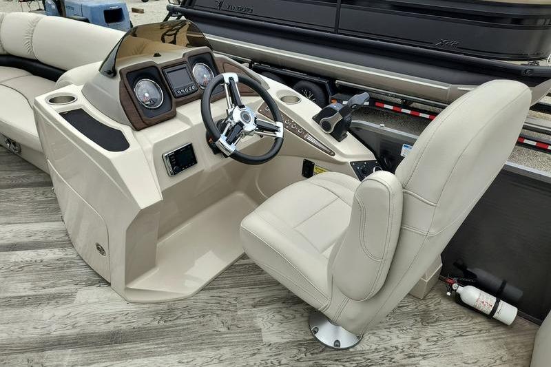 2017 Manitou 25 Oasis SE boat interior with steering wheel and captain's chair.