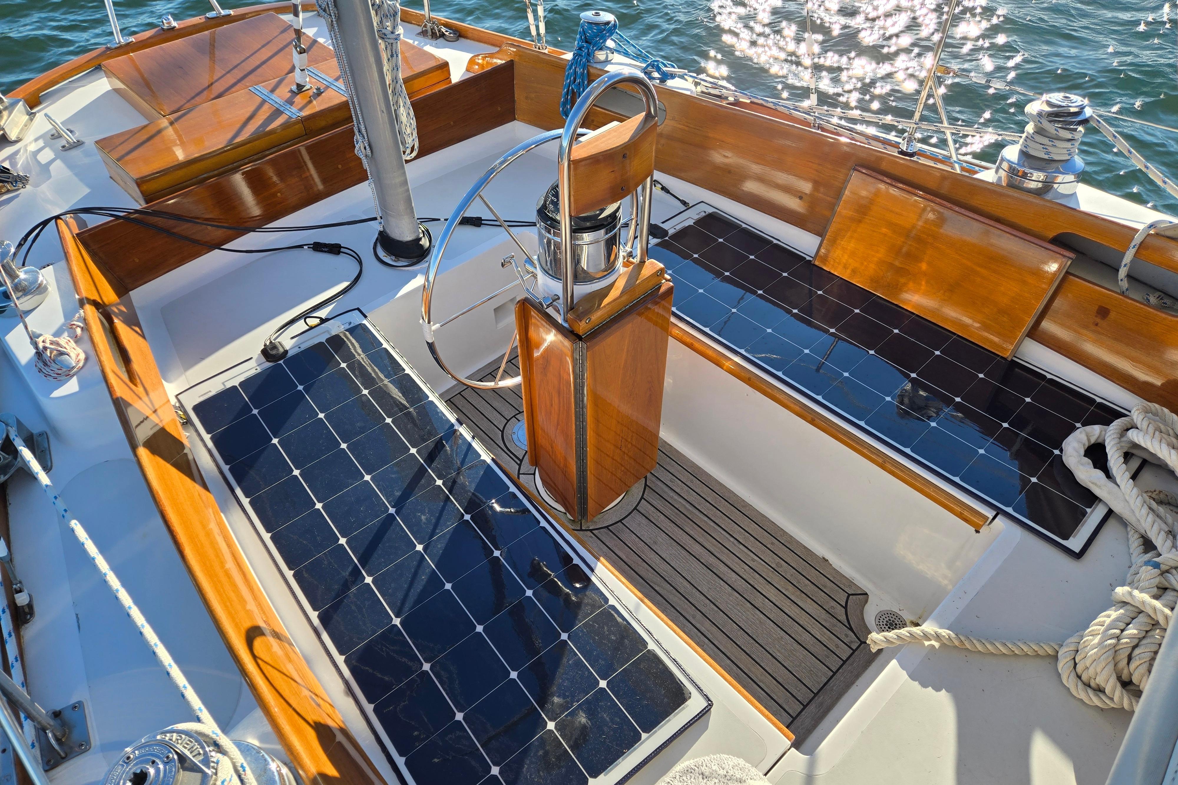 Cockpit of 1970 Hinckley Bermuda 40 sailboat with solar panels and wooden accents.