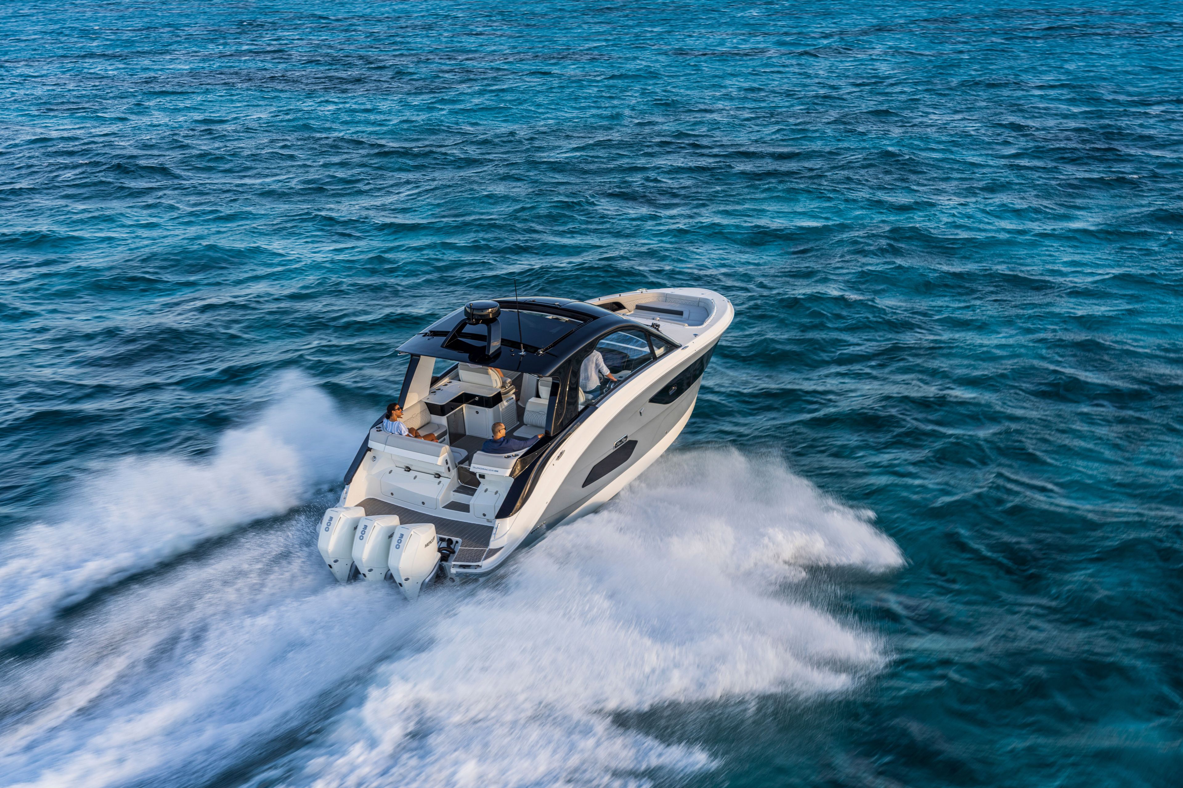 A 2026 Sea Ray Sundancer 370 Outboard speeding across the blue water.