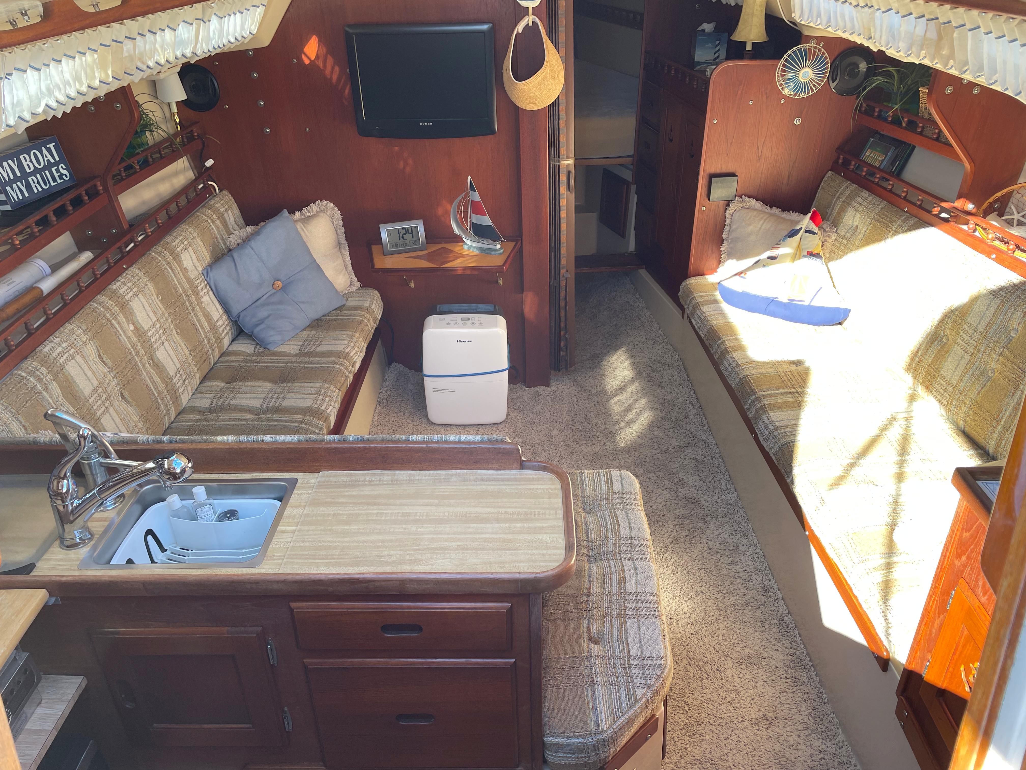 Interior of a 1982 Catalina 30 sailboat with cozy seating and compact kitchen area.