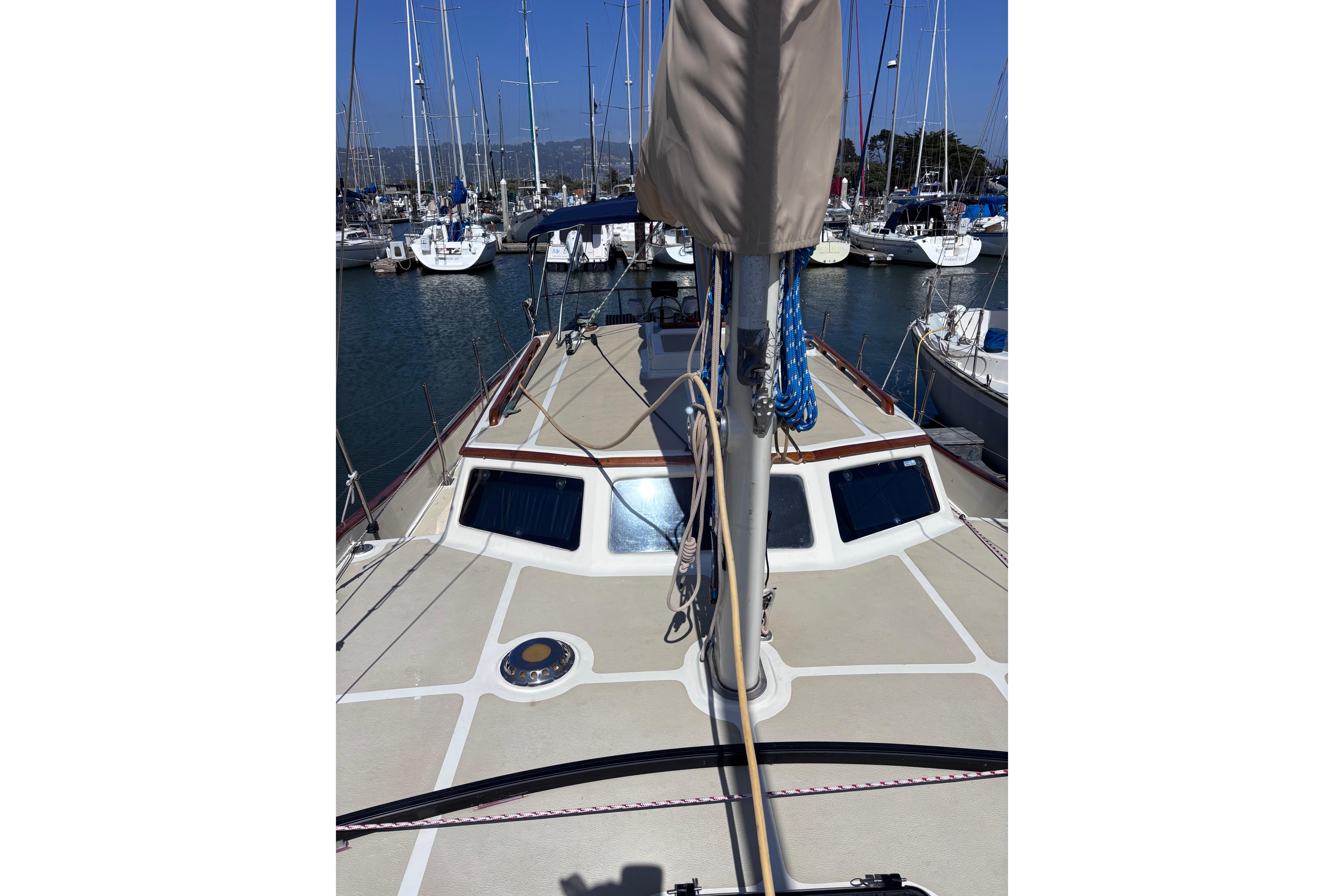 1978 Swift 33 sailboat deck view in marina, surrounded by other boats.