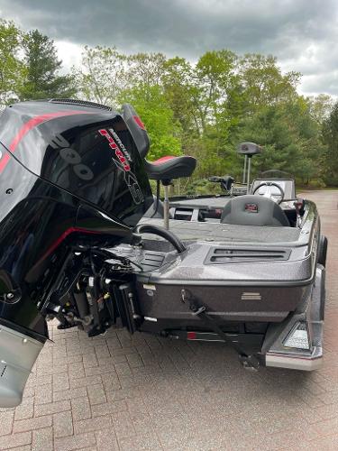 2025 Ranger Z518 boat with powerful outboard motor, parked on paved surface, surrounded by trees.